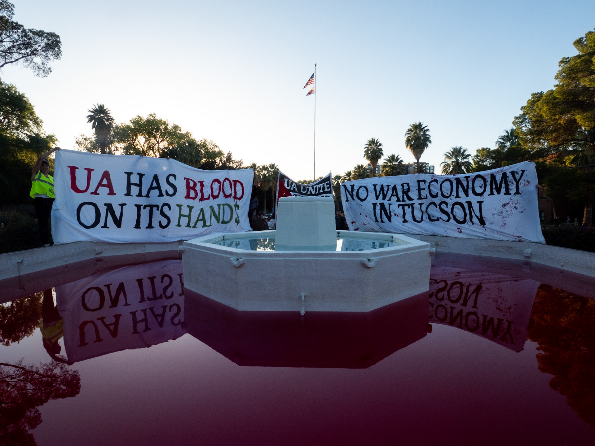 Signs behind the Fountain in front of Old Main at the University of Arizona after getting dyed red at the Shut It Down For Palestine Global Day of Action on November 9th. The event was put on by the Arizona Palestine Solidarity Alliance, the Tucson Peace Center, The Party for Socialism & Liberation and more.