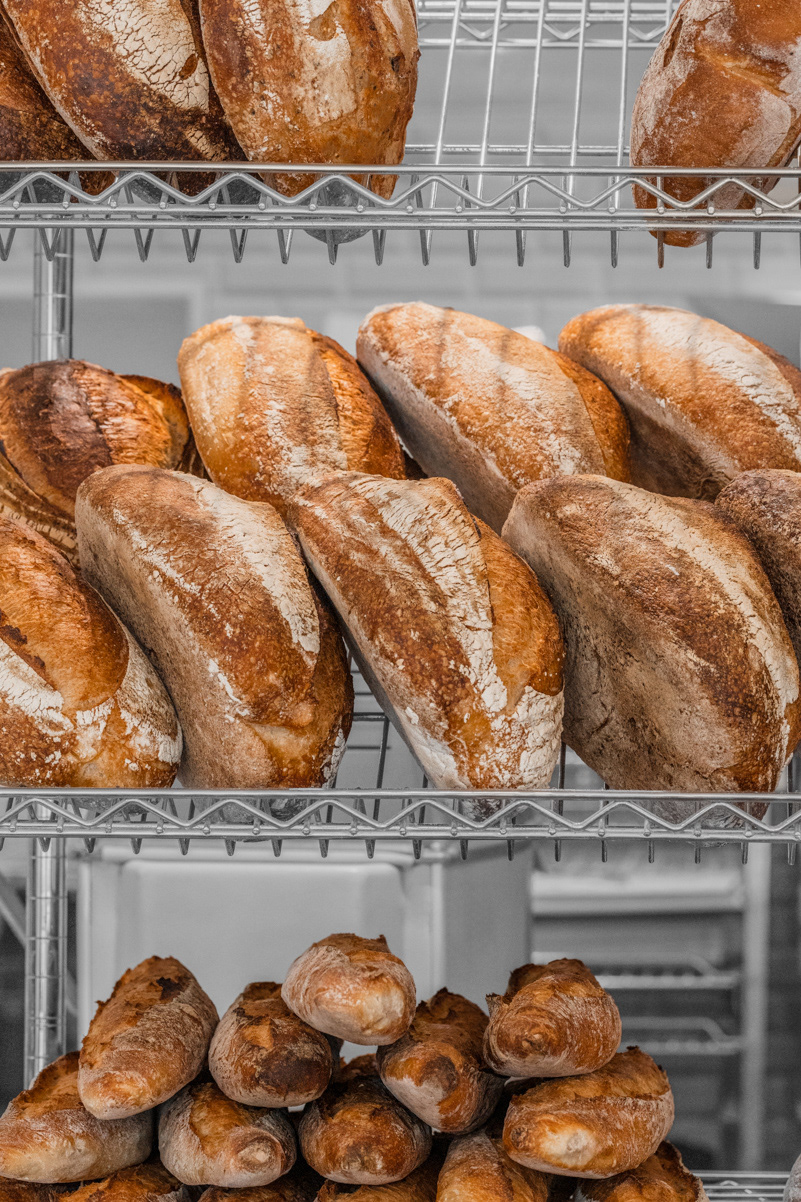 A hospitality image showcasing a local bakery's freshly baked bread, presented on a presentation rack, shot by Ioana Ursu cafe and restaurant photographer based in Warwickshire