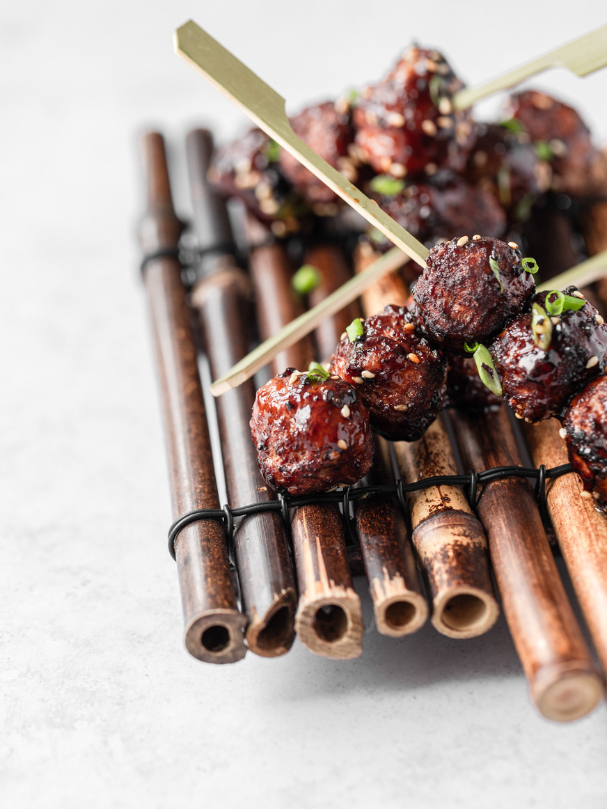 A restaurant photography image of meatballs on skewers, presented on a bamboo plate made by Ioana Ursu food and hospitality photographer based in Warwickshire