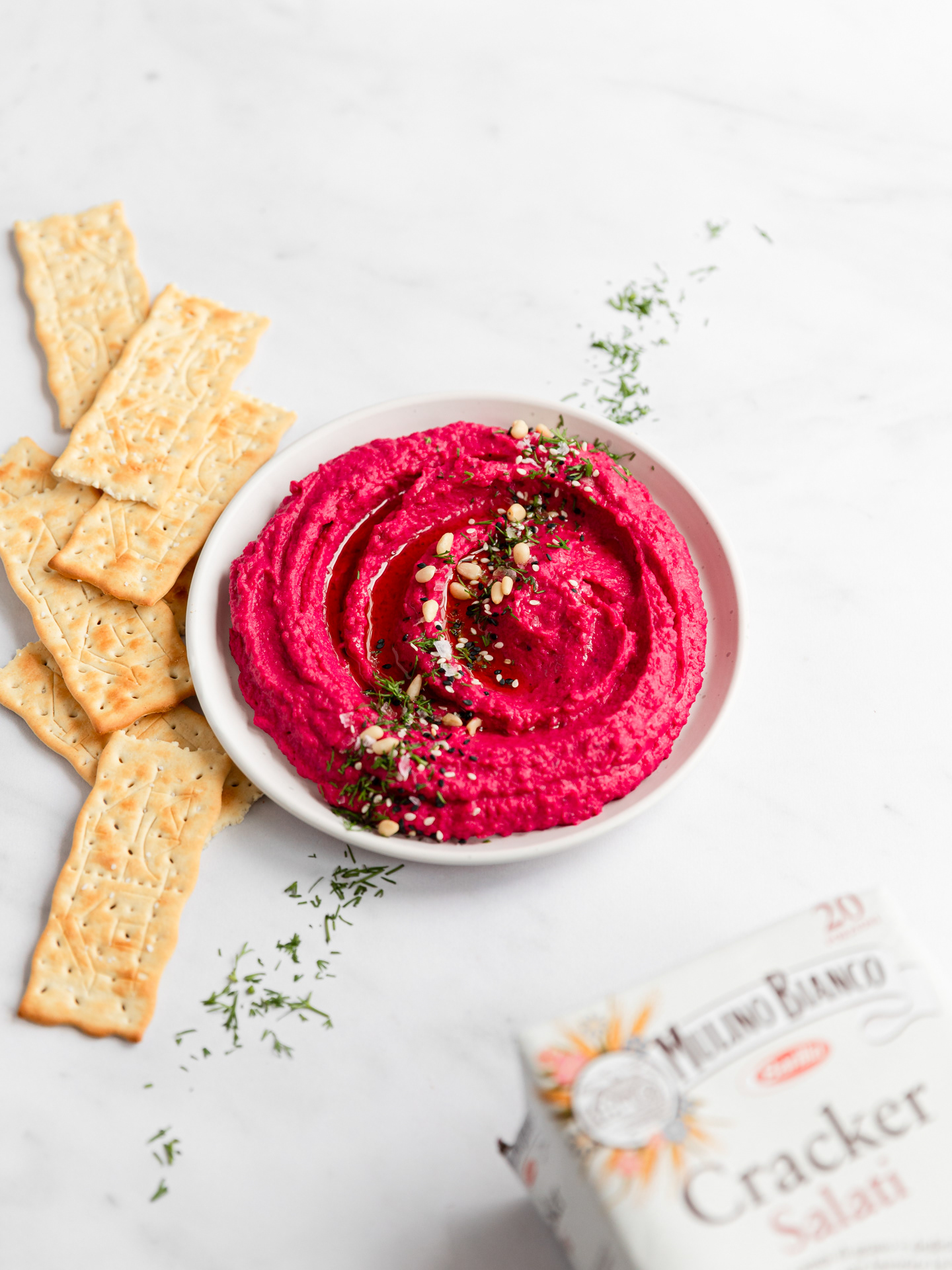 A product portfolio images made with Mulino Bianco crackers served with a homemade beetroot hummus served in a. bowl and topped with dill and pine nuts photographed by Ioana Ursu for Photography Portfolio