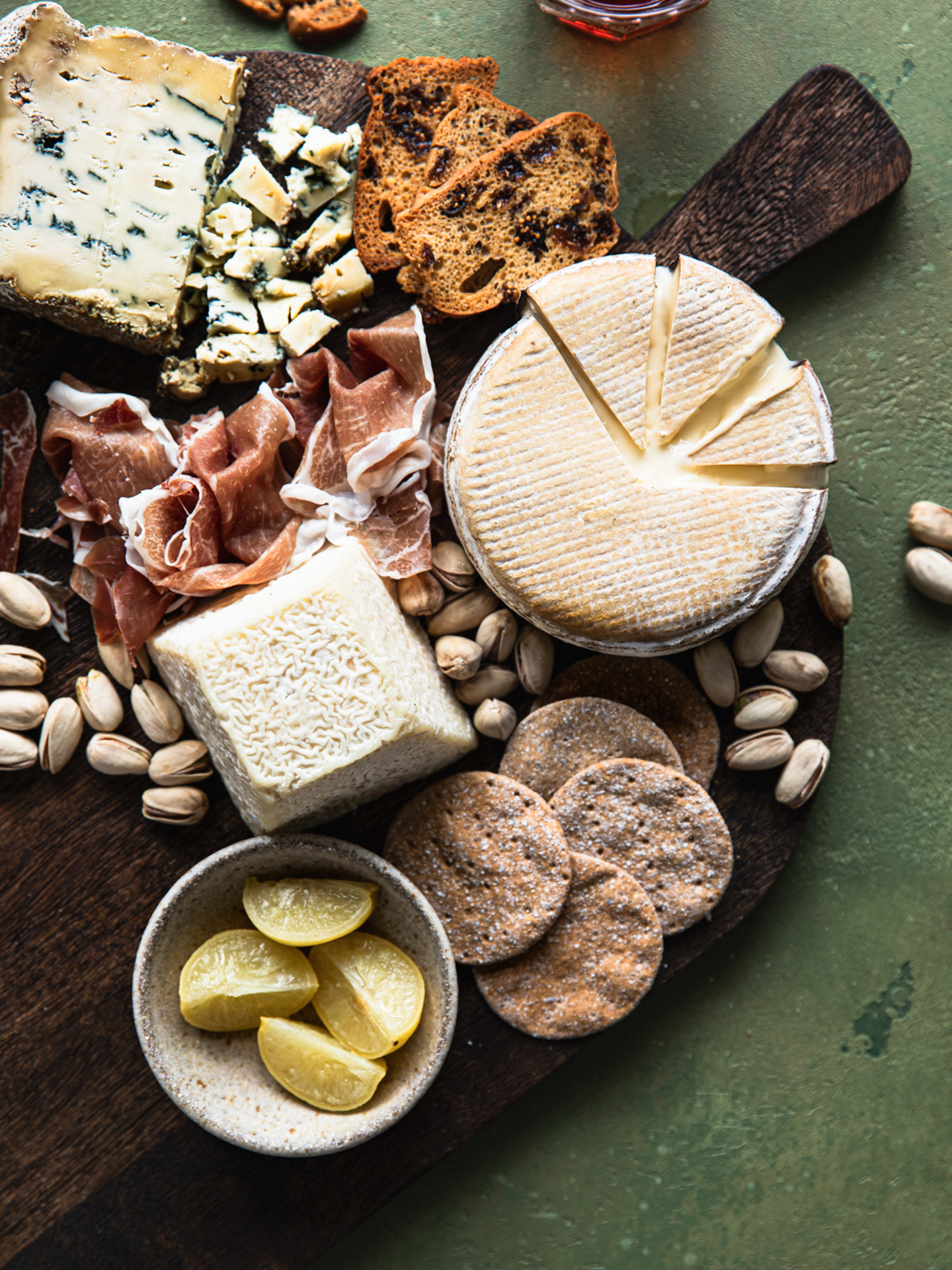 An image of a cheeseboard and charcuterie board on a wooden board made by Ioana Ursu Food Photographer and Stylist in Warwickshire, UK