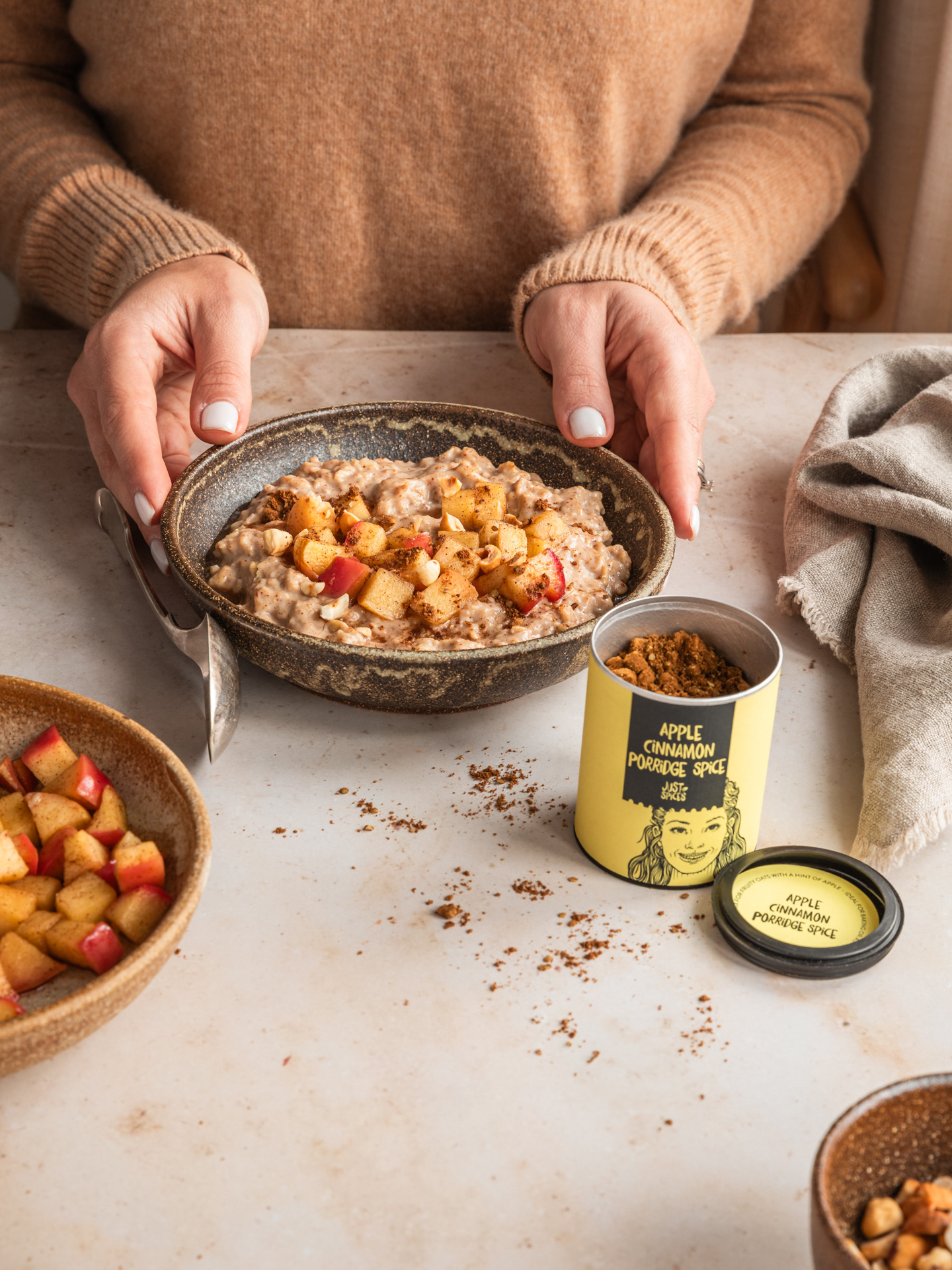 A food and product portfolio image photographed by Ioana Ursu - food and product photographer based in Warwickshire. This is a food image of a porridge meal in a bowl served with cooked apples and a sprinkle of apple cinnamon porridge spice
