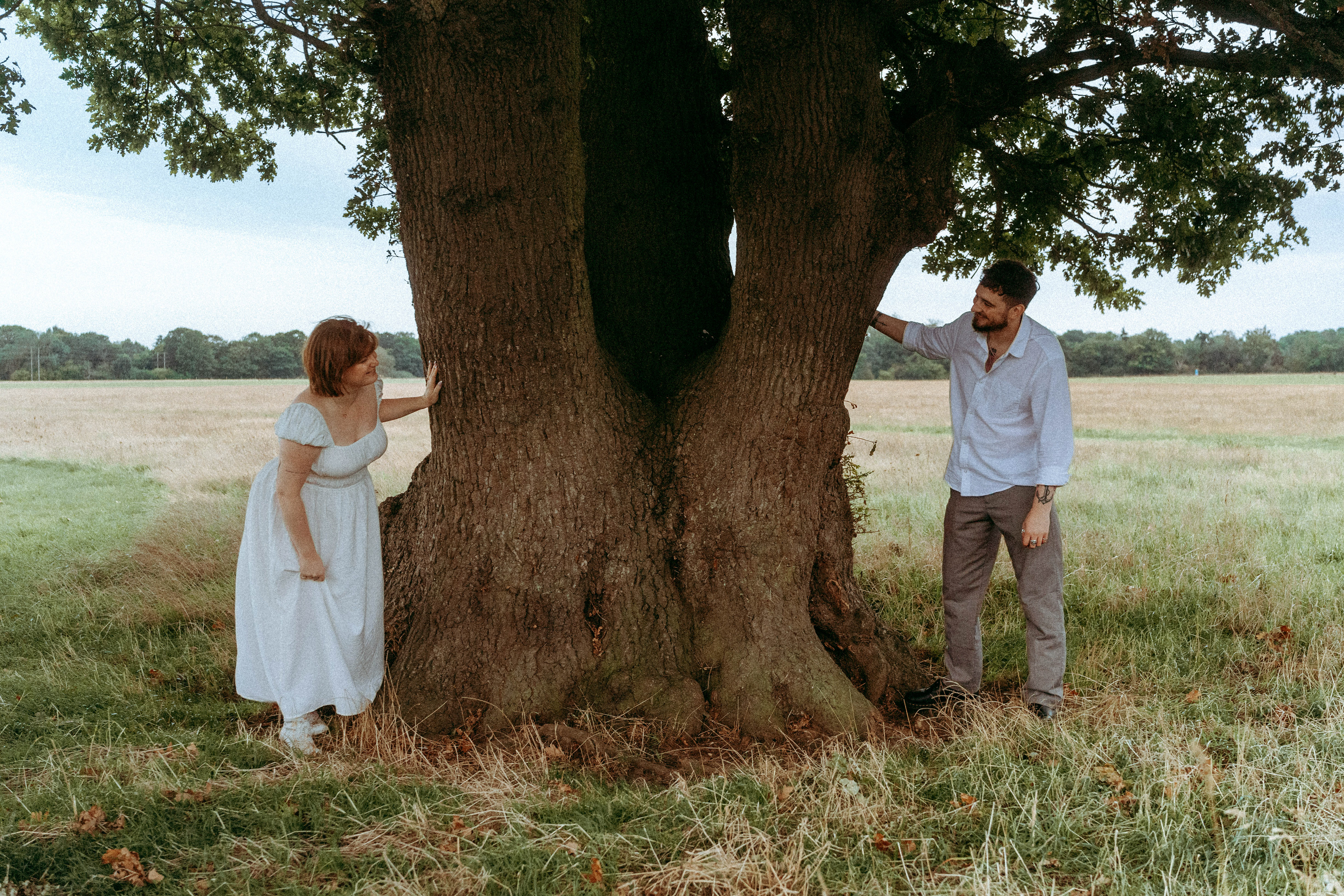 An intimate and playful engagement story set against a grand oak tree. A blend of romantic lifestyle photography and high-end editorial portraits, featuring a curated picnic setting in the Essex countryside.