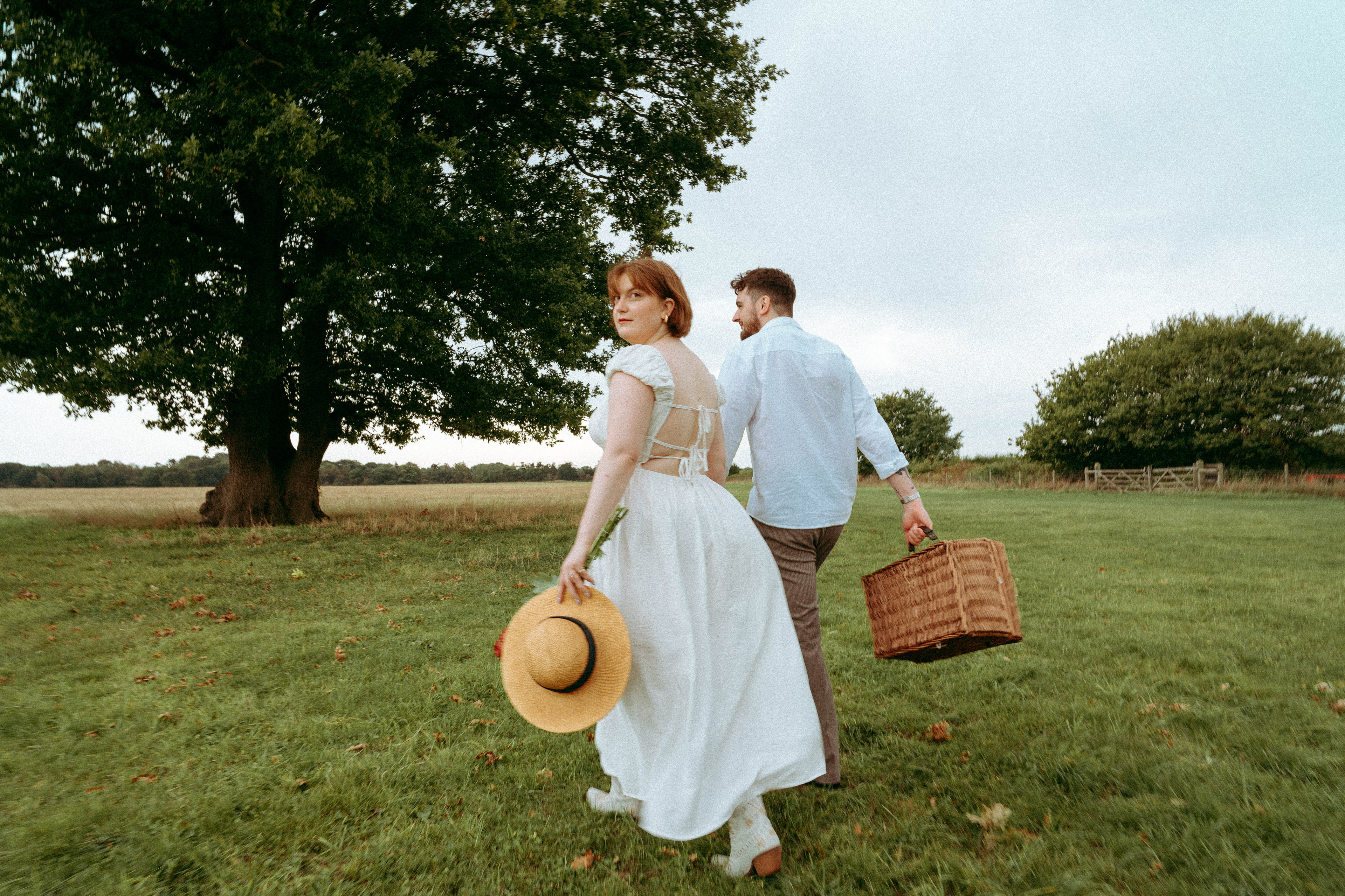 An intimate and playful engagement story set against a grand oak tree. A blend of romantic lifestyle photography and high-end editorial portraits, featuring a curated picnic setting in the Essex countryside.