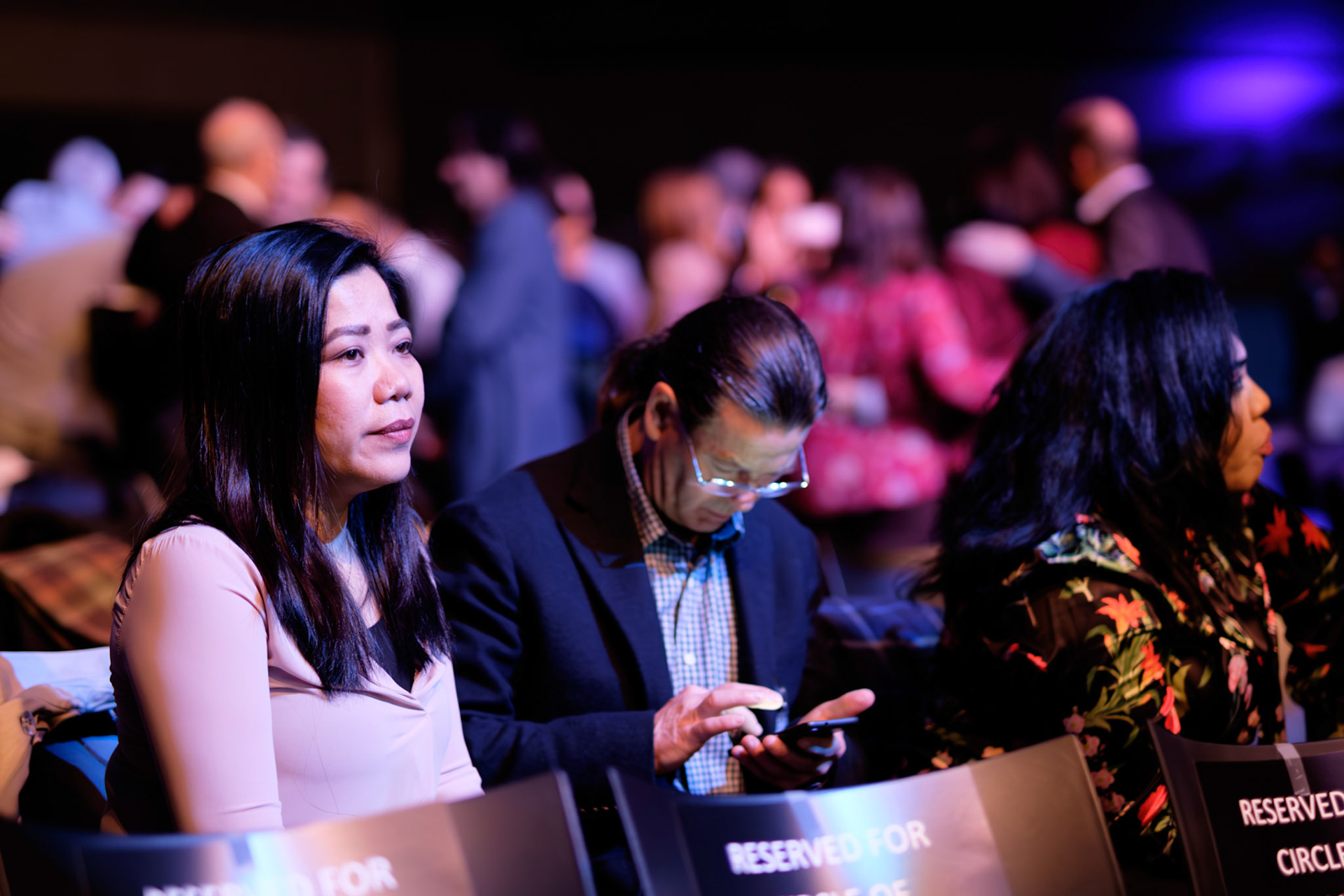 Candid photo of seated delegates at corporate event awaiting keynote speaker