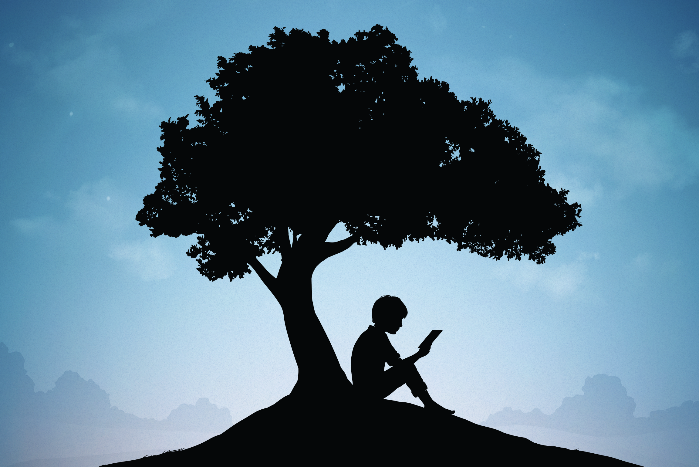 silhouette of boy reading under tree
