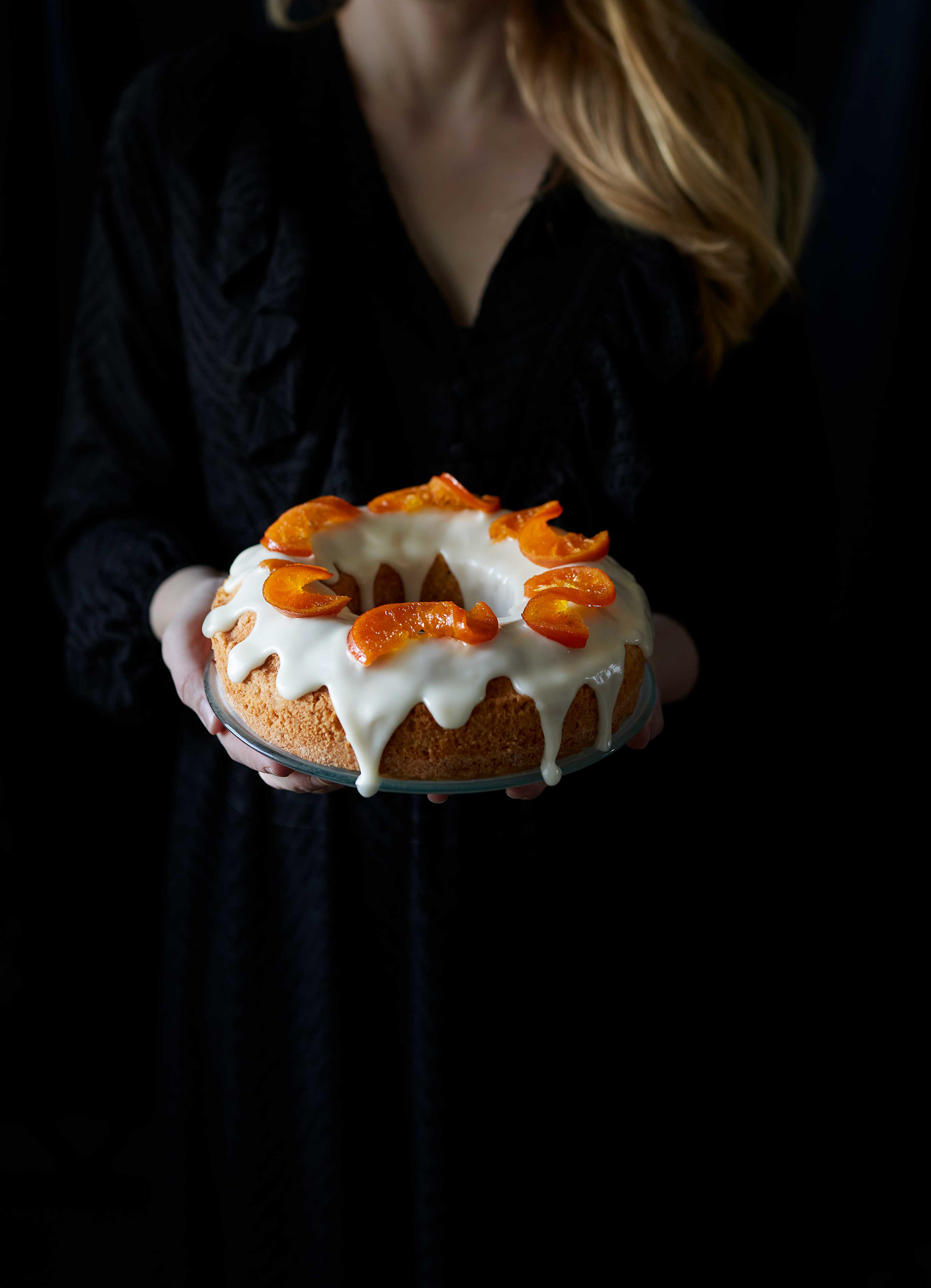 Nainen pitelee appelsiinikakkua