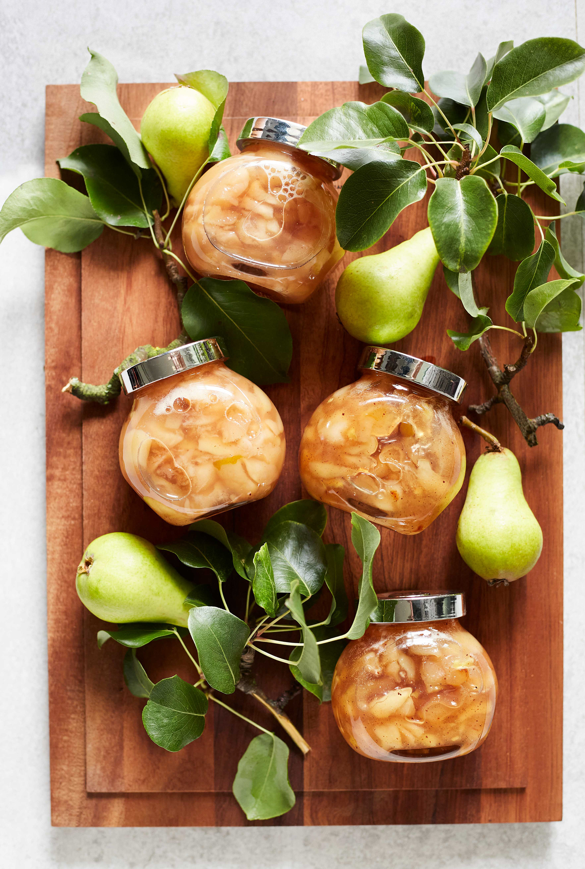 Pieniä purkkeja täynnä hilloa leikkuulaudalla kuvattuna