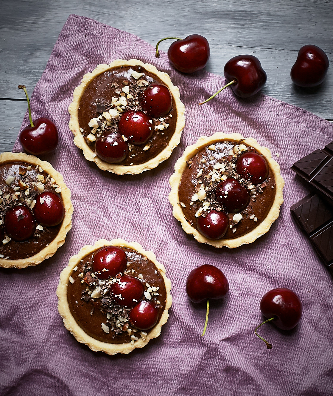 Suklaapiirakoita koristeltuna kirsikoilla