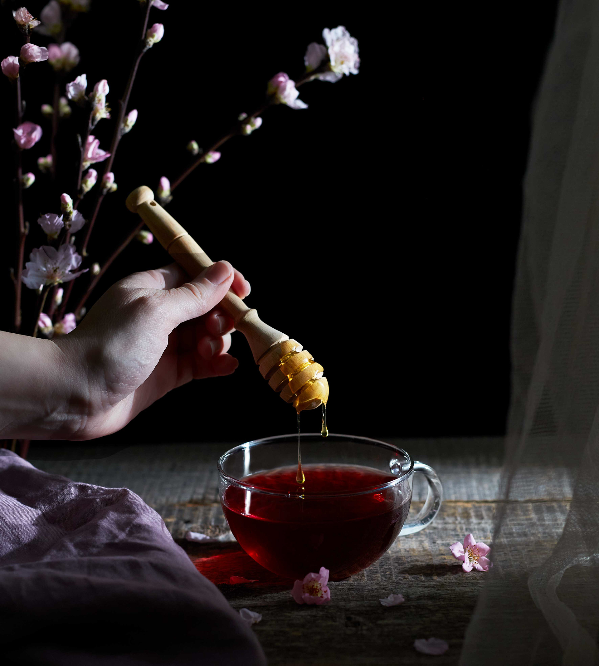 Punaista teetä lasissa ja hunajaa