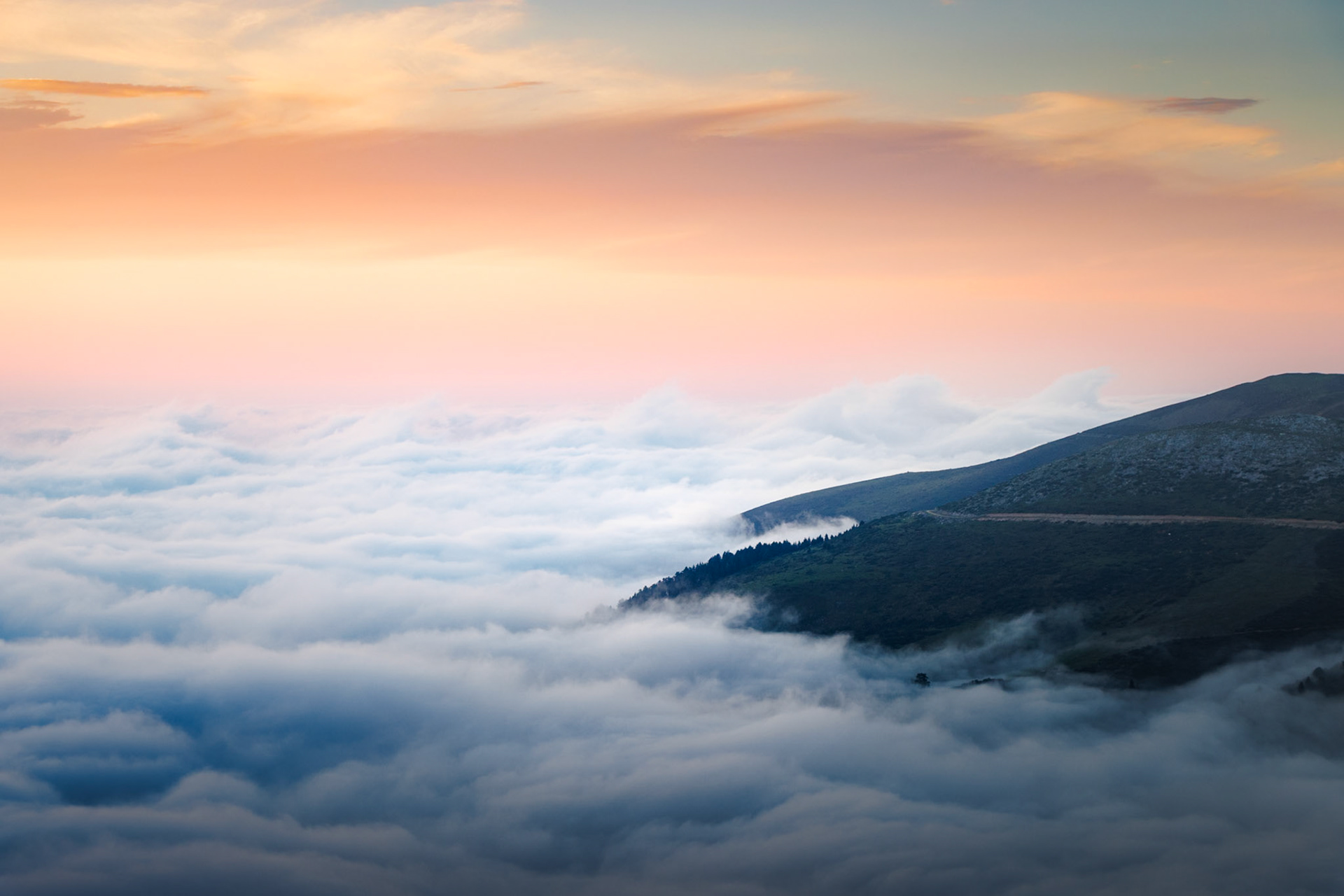 Mer de nuages au coucher du soleil, dans des teintes pastel et aériennes.