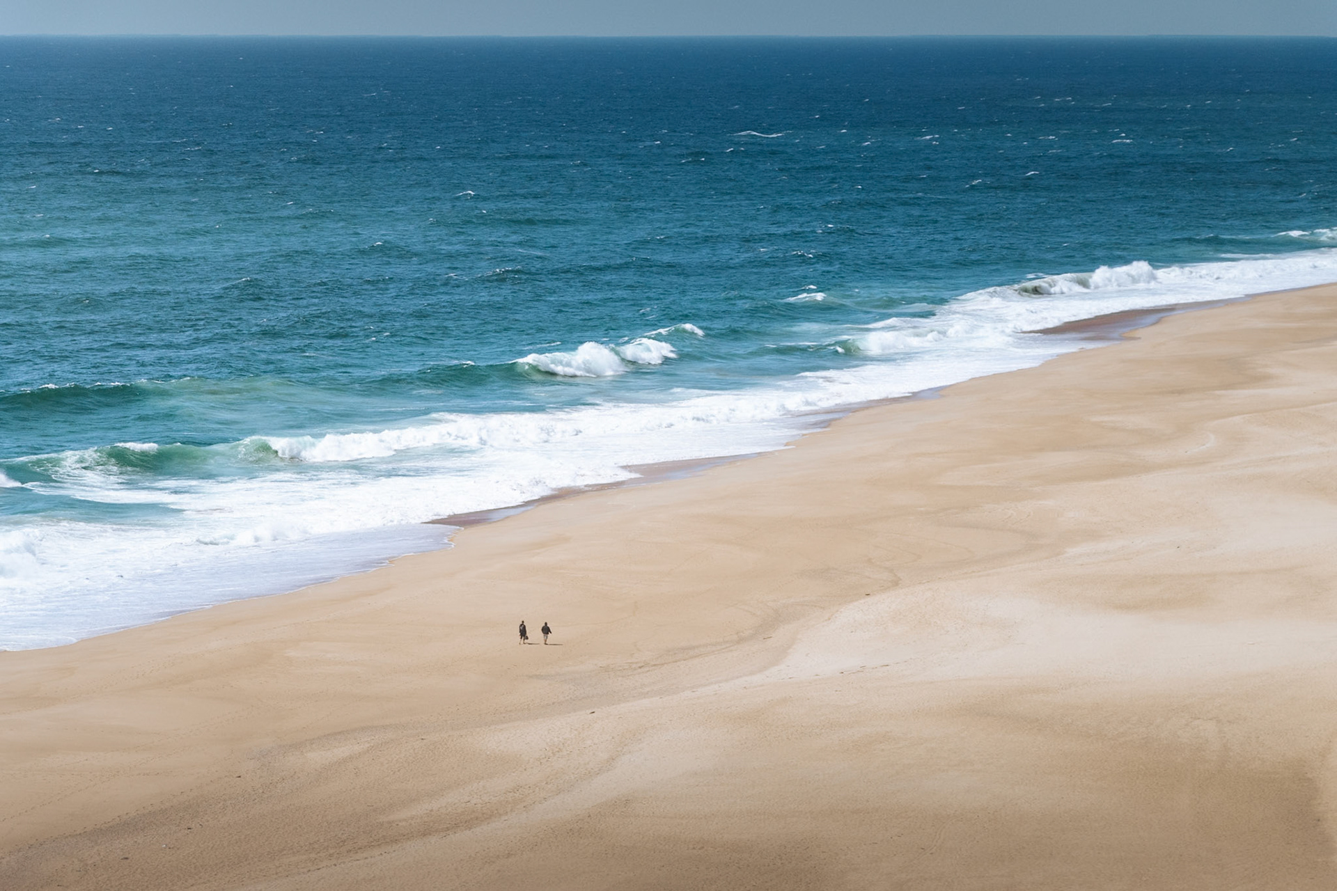 Les grandes plages de Nazaré, balayées par le vent, presque désertes — seul face à l'immensité.