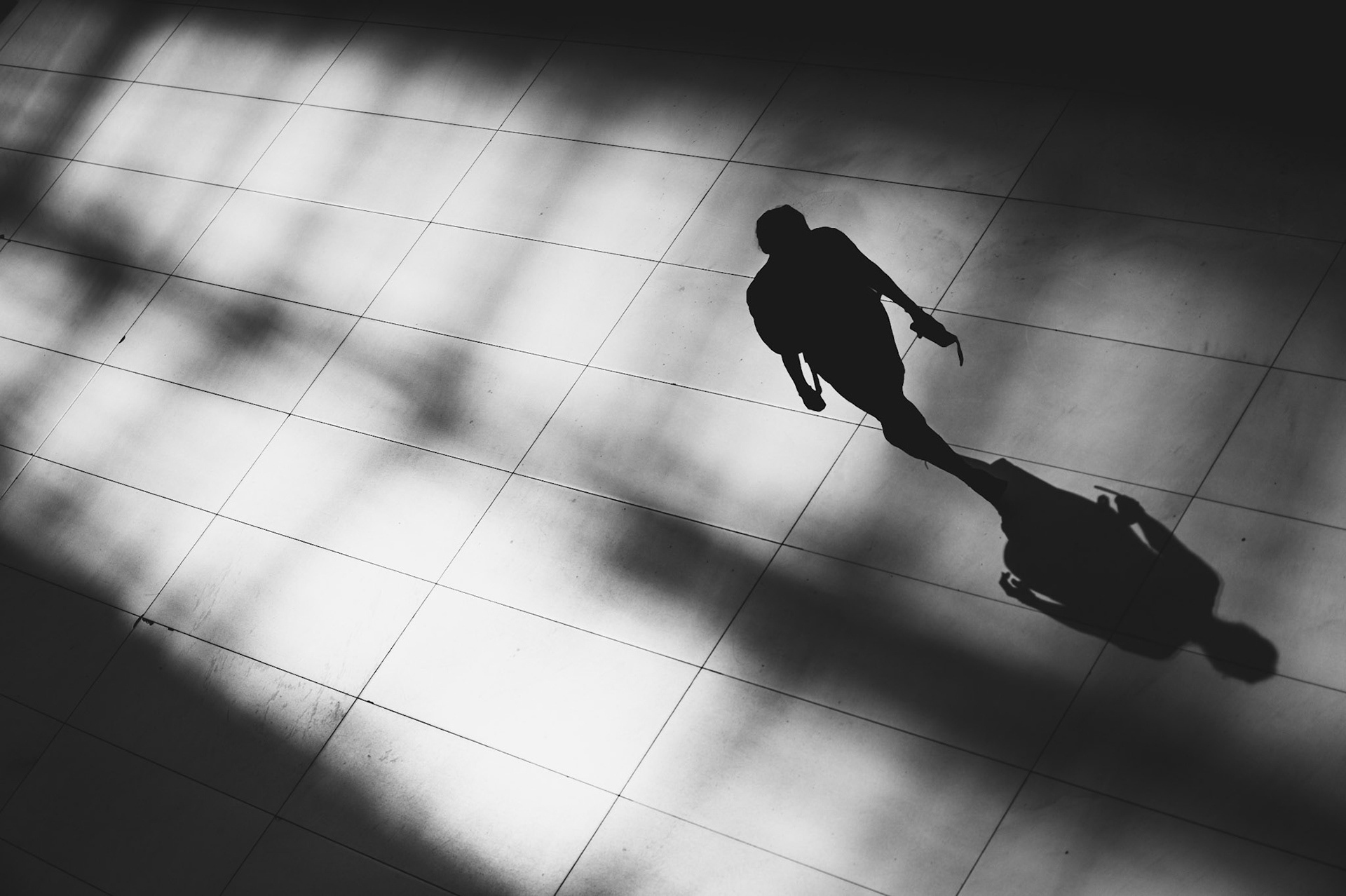 within the striking architecture of the oculus in new york city, a lone figure walks through the interplay of light and shadow on the tiled floor, caught between worlds of clarity and mystery. the sharp lines and dramatic contrast of the space create a delicate balance — a dance between presence and absence, reality and abstraction. as she moves forward, her silhouette merges with the dark shadows, suggesting both purpose and anonymity. the soft transitions of light invite the viewer to ponder: is she stepping into the light or fading into the darkness? a moment of introspection and hidden stories unfolding in one of the city's most iconic spaces.