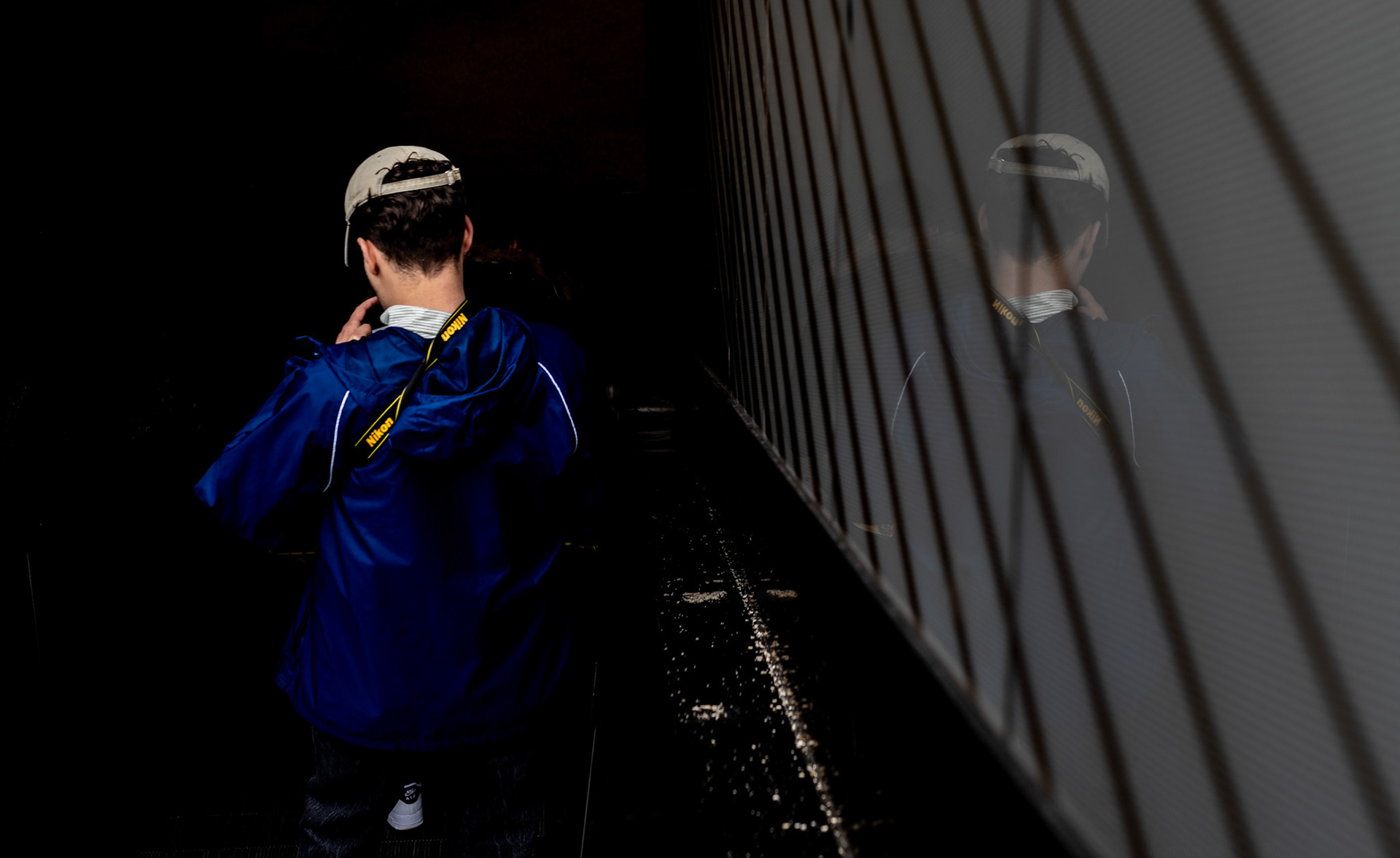 descending into munich's urban artery, the air vibrates with the hum of the city's pulse. each step on the escalator, a gentle descent into the subterranean heartbeat of this historic yet ever-modern metropolis. he carries with him the quiet air of contemplation, a silent witness to the dance of shadows and light that plays across the steel canvas of his surroundings. this is the photographer's retreat, where the clatter of the surface is hushed to a whisper, and the reflections capture more than just shapes, but the essence of movement, the soul of the commuter's journey. it is here, in this liminal space, that he finds a fleeting connection to the city's rhythm, mirrored in the lines that crisscross his path, a visual echo of munich's own intricate melodies.