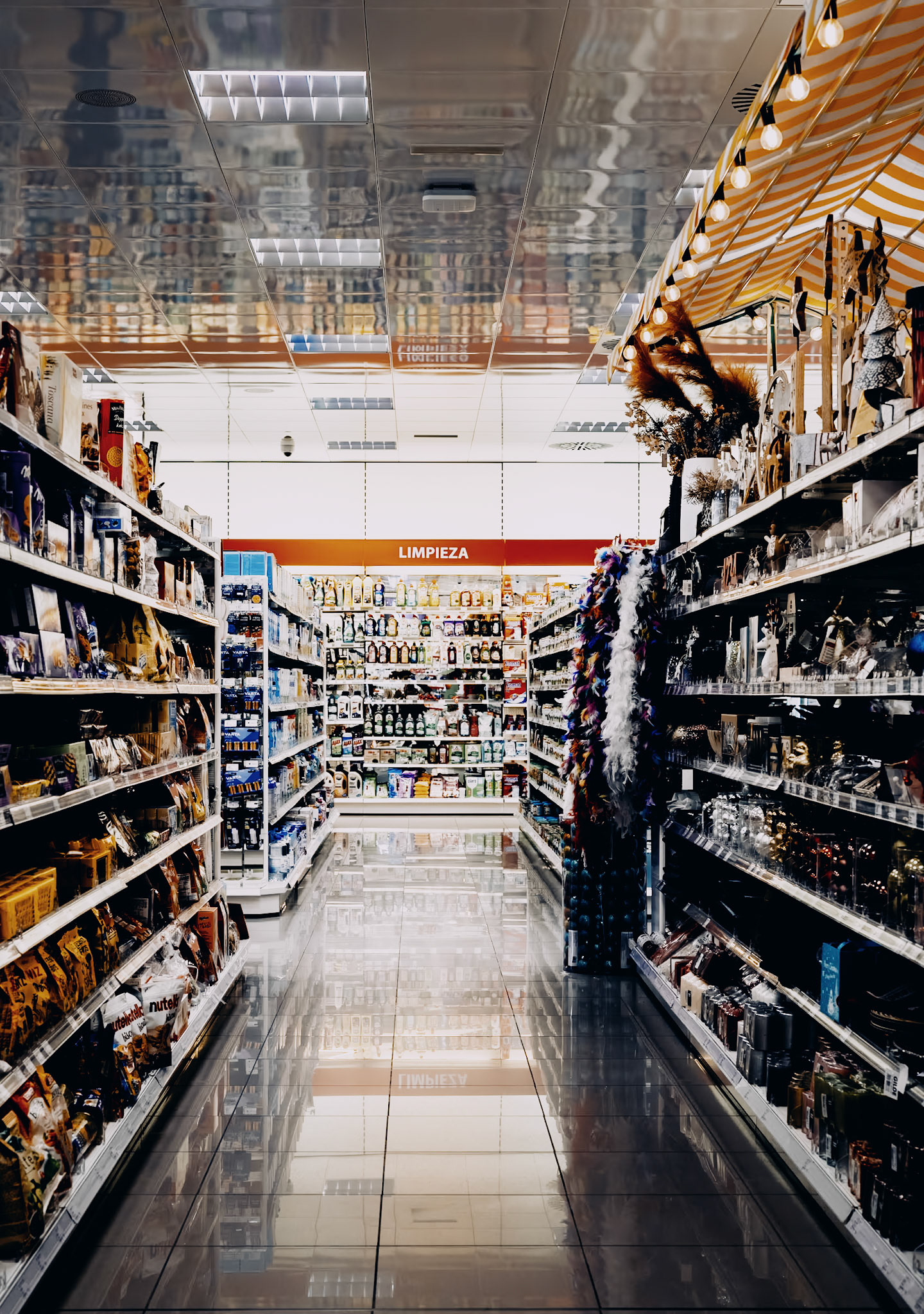 captured a still scene inside the müller drug market, highlighting the neat aisles filled with an array of products. from food items to cleaning supplies, the store offers a diverse selection. the well-lit venue with shiny floors exudes cleanliness and order, typical of a commercial area in the vicinity of palma.