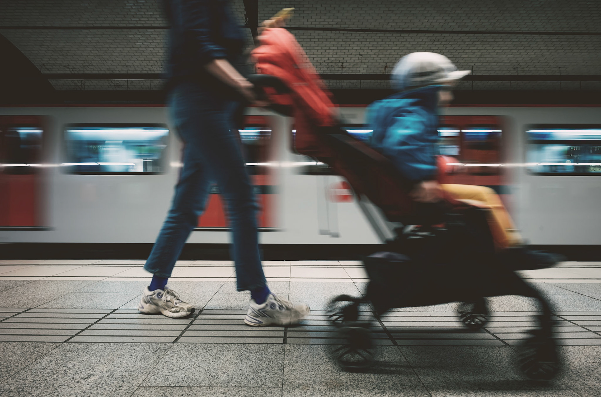 in the subterranean pulse of passeig de gràcia, life moves to the rhythm of coming and going. the motion blur of a mother's stride, a stroller in tow, tells of daily journeys taken beneath the city's skin. with each train's arrival, a gust of wind; with each departure, a story sweeps past the platform. this frame, a fleeting intersection of lives in transit, is but a brushstroke in the mural of urban existence. it's here in the blur, the journey becomes the destination—each step a silent note in the symphony of the mundane.