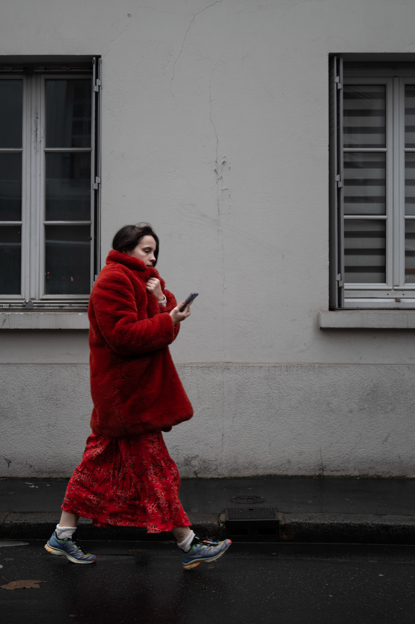 a striking contrast between the vivid red coat and the gray urban setting. walking through the rainy streets of paris, even the simplest moments can feel cinematic.