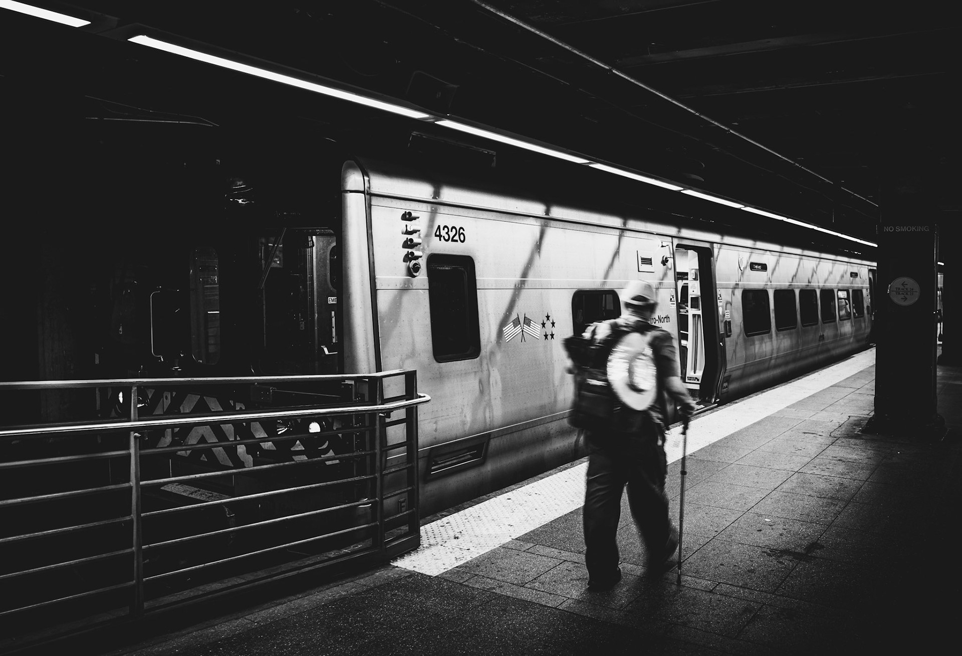 grand central station. a place that pulses with millions of lives, but where no one really stops. he’s a shadow in transit—hat tilted, staff in hand, moving toward an unknown destination. the metallic sheen of the train reflects its purpose: efficiency, anonymity, endless motion. you don’t ask who he is. the story’s in the movement, the blur, the urgency. the city doesn’t pause for anyone, not even here, beneath the vaulted echoes of one of its most iconic heartbeats.