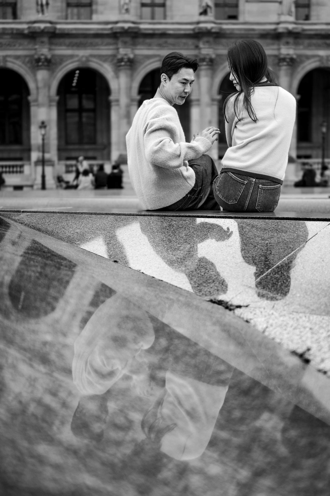 as i wandered through the louvre on a gray day, i found myself overwhelmed by the crowd and the barricades that obscured the famous architecture. but then i spotted something different — a reflection. the marble surface of an empty fountain subtly mirrored the world above it, and in that reflection, i saw this sweet couple, gently teasing each other like young lovers do. it was a moment of love captured in a place that often feels impersonal, and the quiet reflection turned an ordinary scene into something intimate and special.