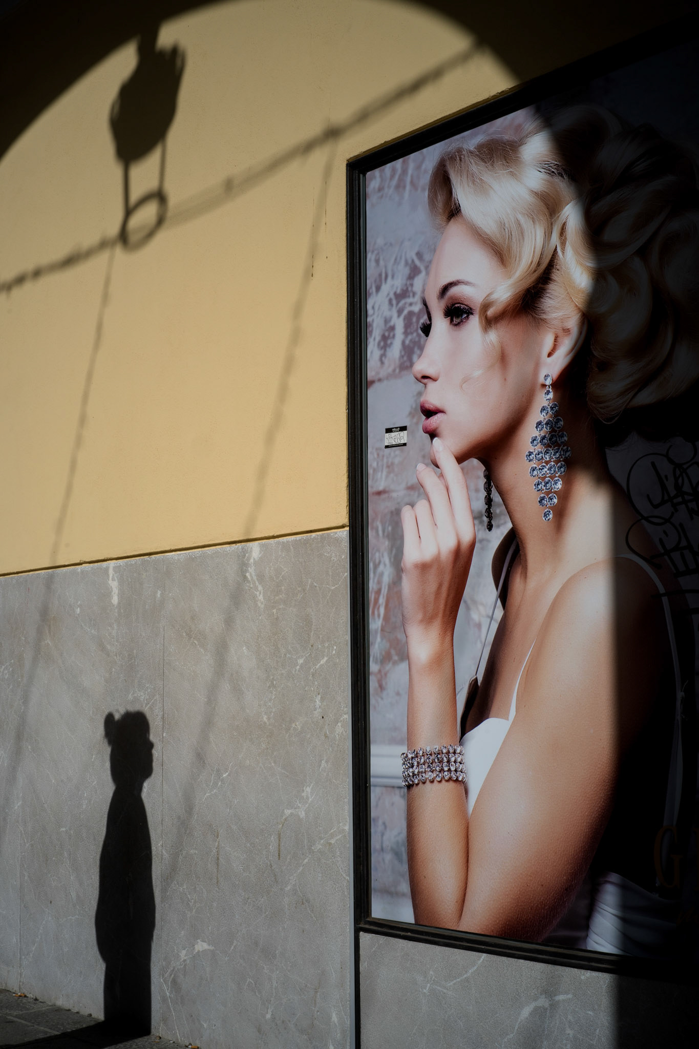 on plaza mayor in palma, i stumbled upon this fleeting moment: a shadow meeting perfection. a passerby’s outline interrupts the polished fantasy of an idealized beauty. the street takes over. it tells its own story. no perfection here, just contrasts—raw, real, and human.  this is what photography is about: seeing the dialogue between light and shadow, the ordinary and the untouchable. it’s the poetry of the everyday. and sometimes, if you’re lucky, it all comes together in a single frame.