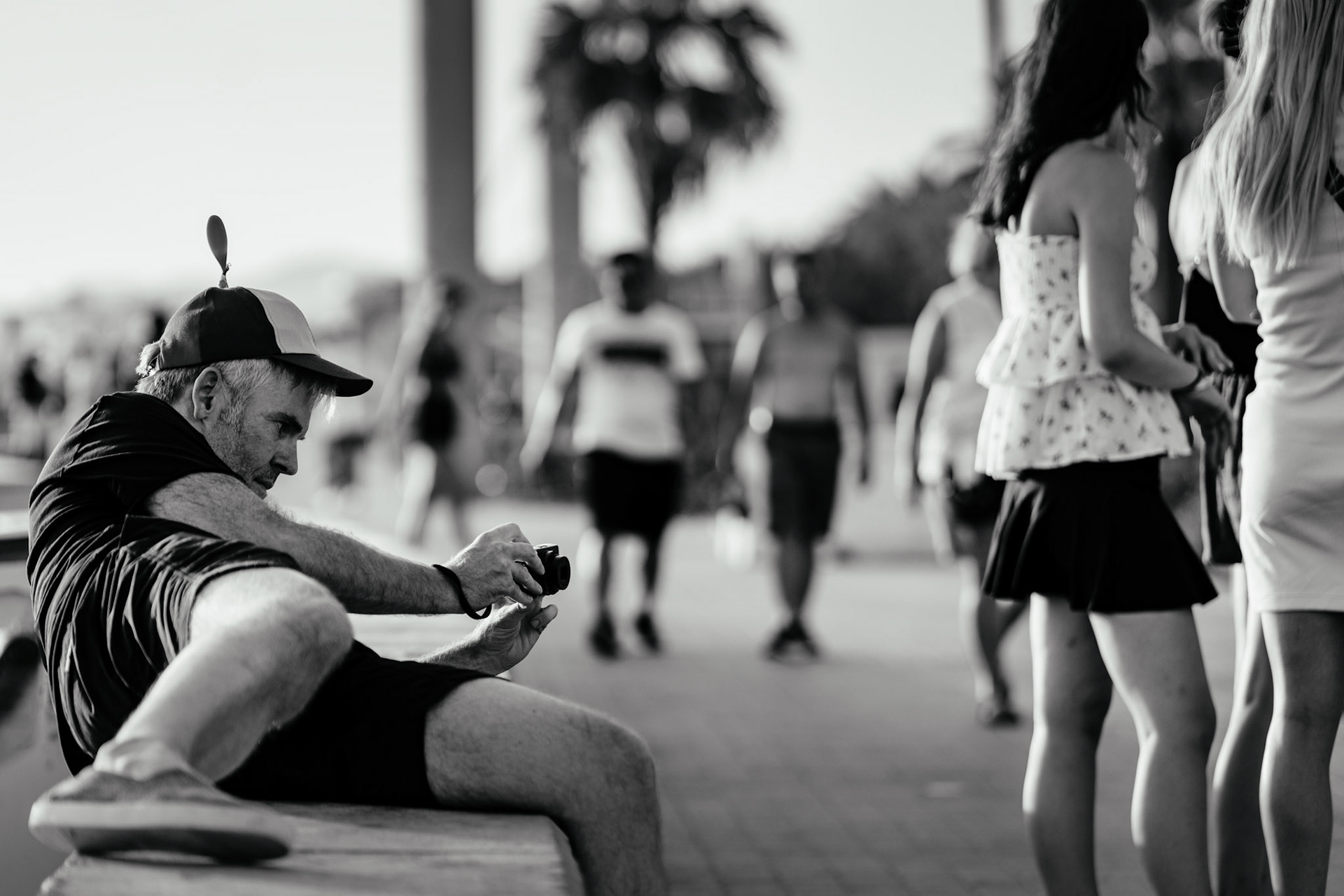 in el arenal, where the sun-soaked streets echo with stories of leisure and carefree days, thomas blends into the vibrant scene, not with stealth, but with humor. his propeller hat, a playful nod to the fun-loving spirit of the place, spins lightly in the warm breeze, a beacon of cheerful irony among the more predictable beach attire. thomas, camera in hand, captures the pulse of the "deutsche meile," leaning in, crouching low, every movement a dance with the lens. here, amidst the blend of german voices and spanish charm, he’s not just a photographer; he’s part of the scenery, recording the day with a wink and a grin. the photo, no doubt, will reflect the same—joyful, alive, and just a bit mischievous.