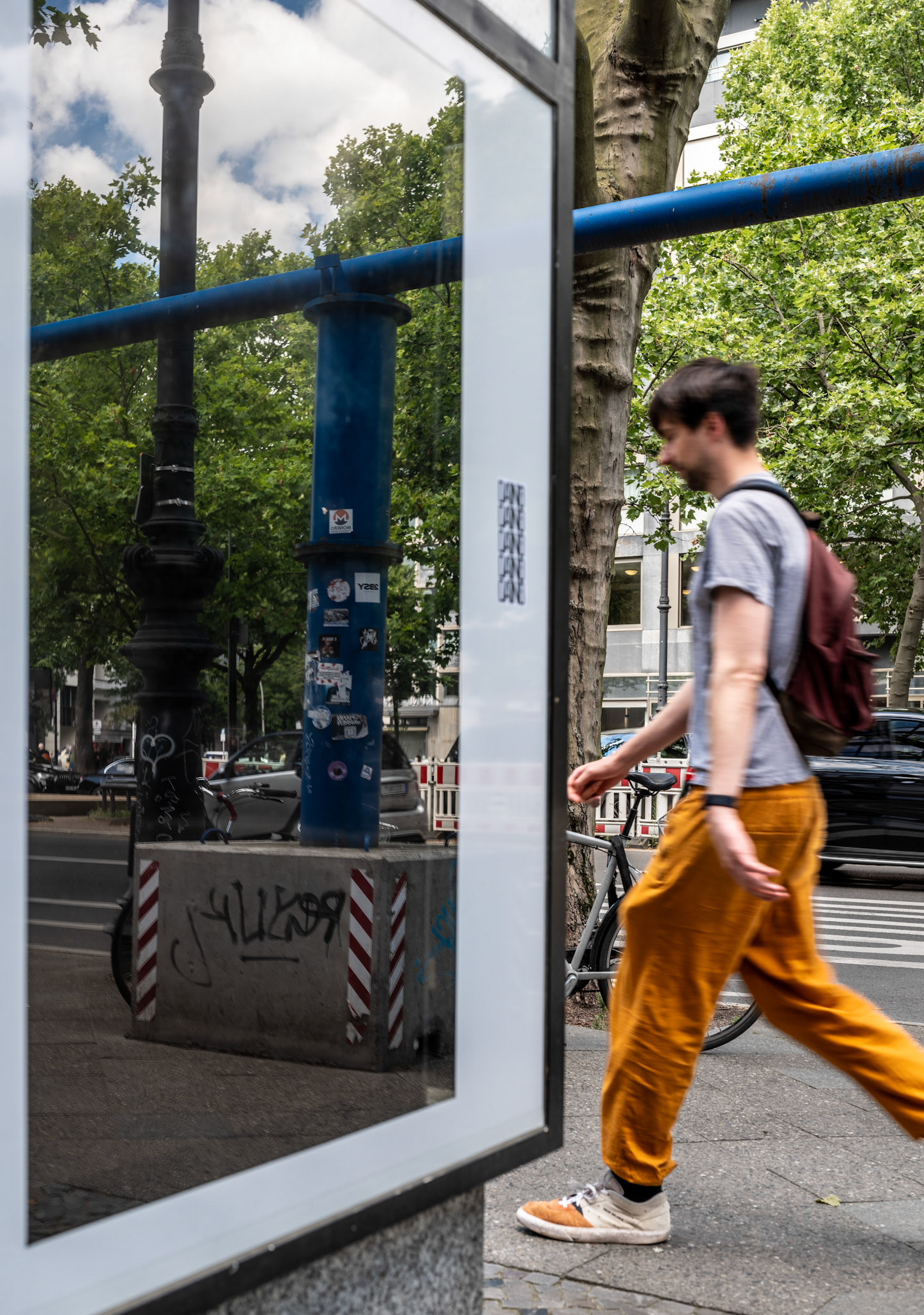captured on kurfürstendamm in berlin, this photo plays with perception through a striking reflection. construction pipes appear to continue seamlessly in the glass of a display case, creating an optical illusion that challenges the viewer's sense of reality. the juxtaposition of a passing figure against the stillness of the reflected scene adds a dynamic element to the composition. this shot captures the unexpected intersections of urban life, where reflections and realities blend into a captivating visual story.