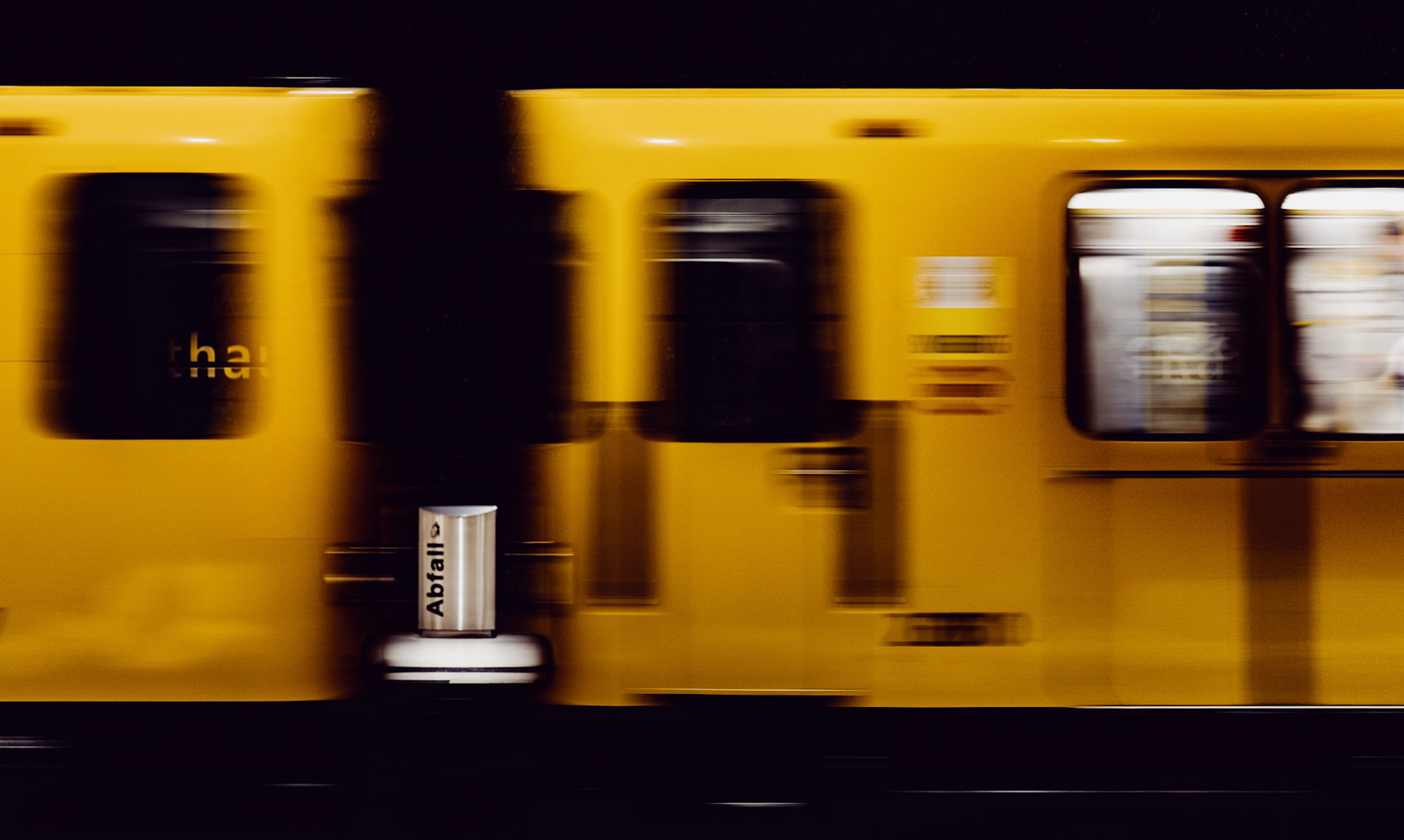 a blur of yellow streaks through the station as berlin’s iconic trains speed past, leaving a moment of stillness in the center. the "abfall" trash bin stands unmoved, grounding the image in its quiet symmetry. captured at just the right second, this photograph contrasts movement with stillness, bright color with dark texture. it’s a fleeting moment in a bustling city where motion rarely stops, and yet here, in the midst of the rush, time feels momentarily paused.