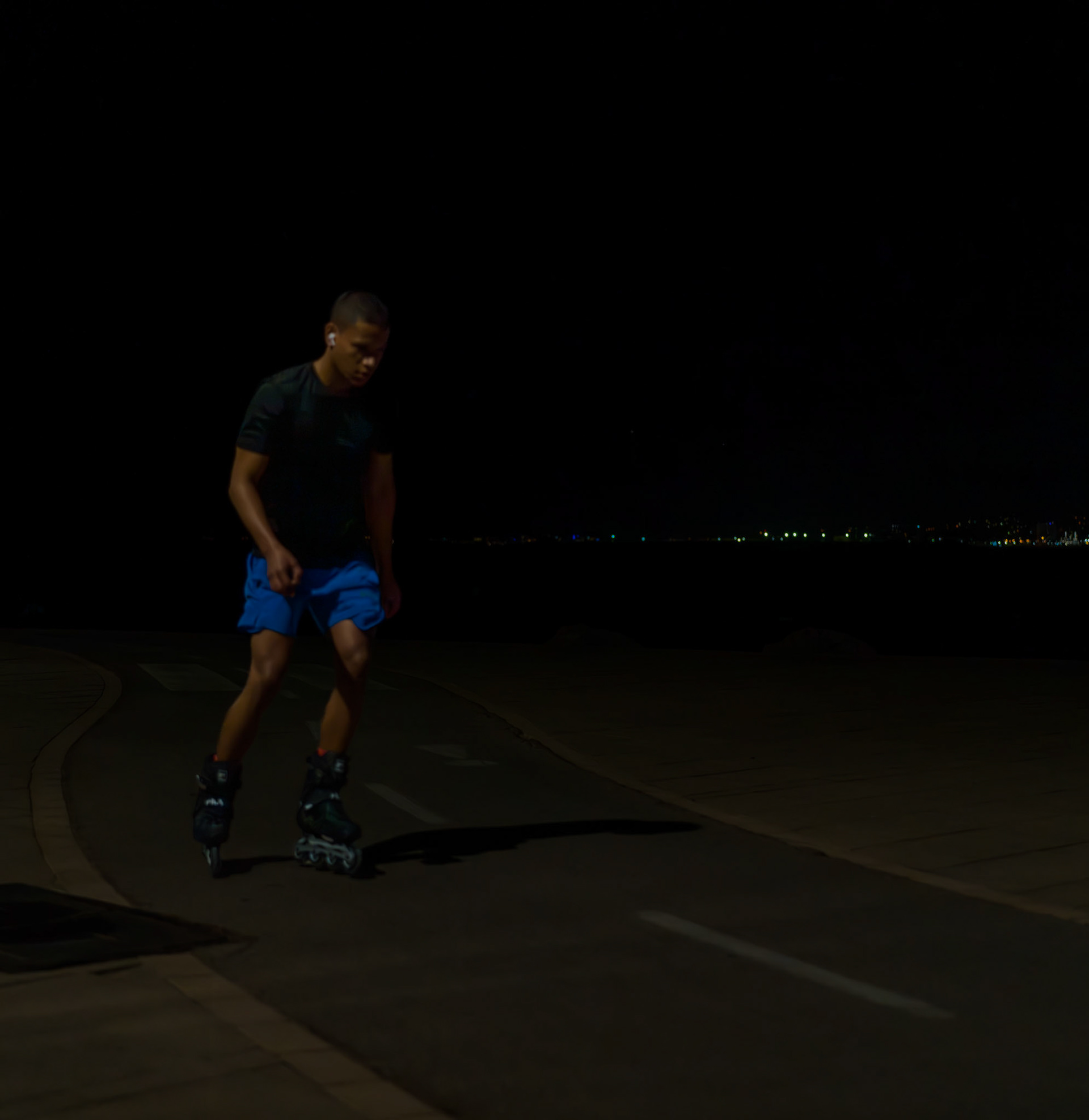 along the moonlit path of portixol, a rollerblader carves the night, his figure sharp against the ambient glow of distant city lights. this scene captures a solitary journey under the stars, where the skater merges with the rhythmic pulse of the night. the dark sky meets the deeper blues of the sea, and the scattered city lights reflect like scattered diamonds on water. every turn and glide of the rollerblader seems to write silent poetry in the air, as he moves fluidly through the quiet, his presence almost like a whisper against the vast, echoing space.