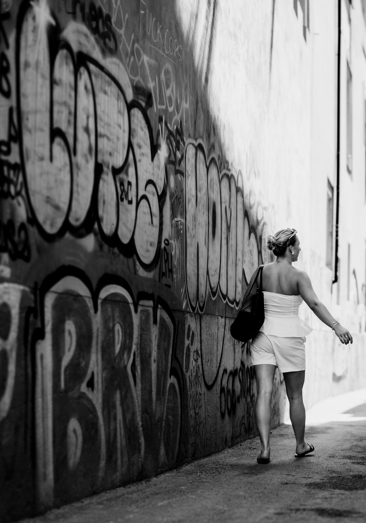 as the afternoon sun starts to dip, shadows deepen and the urban canvas comes alive. wandering through the alleys of la lonja, the contrast between the vibrant graffiti and the poised figure in white creates a juxtaposition of chaos and calm. it’s in these unnoticed corners of palma where the city's true rhythm beats, blending modern street art with timeless elegance.