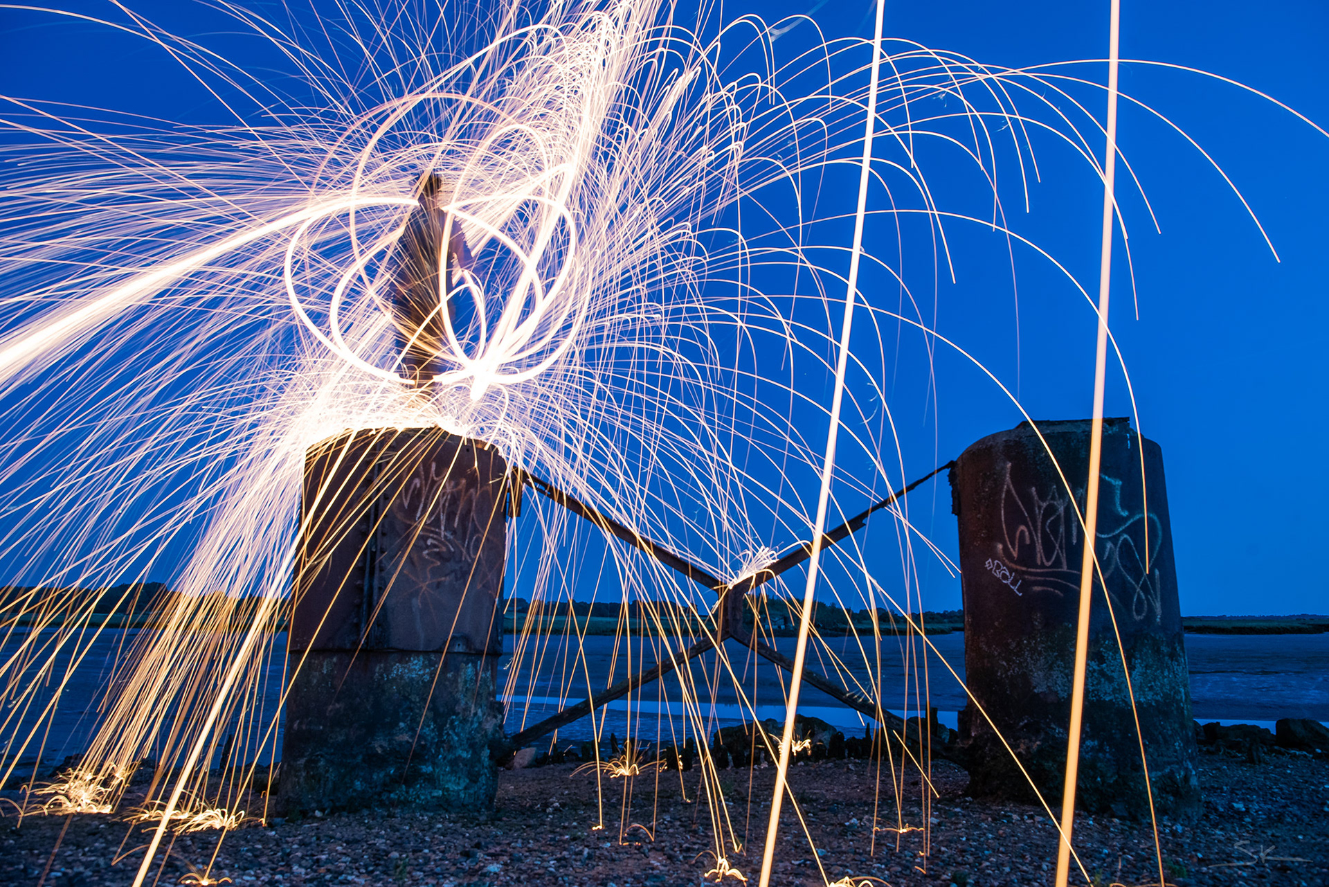 steel wool spinning on a concrete pillar with graffiti