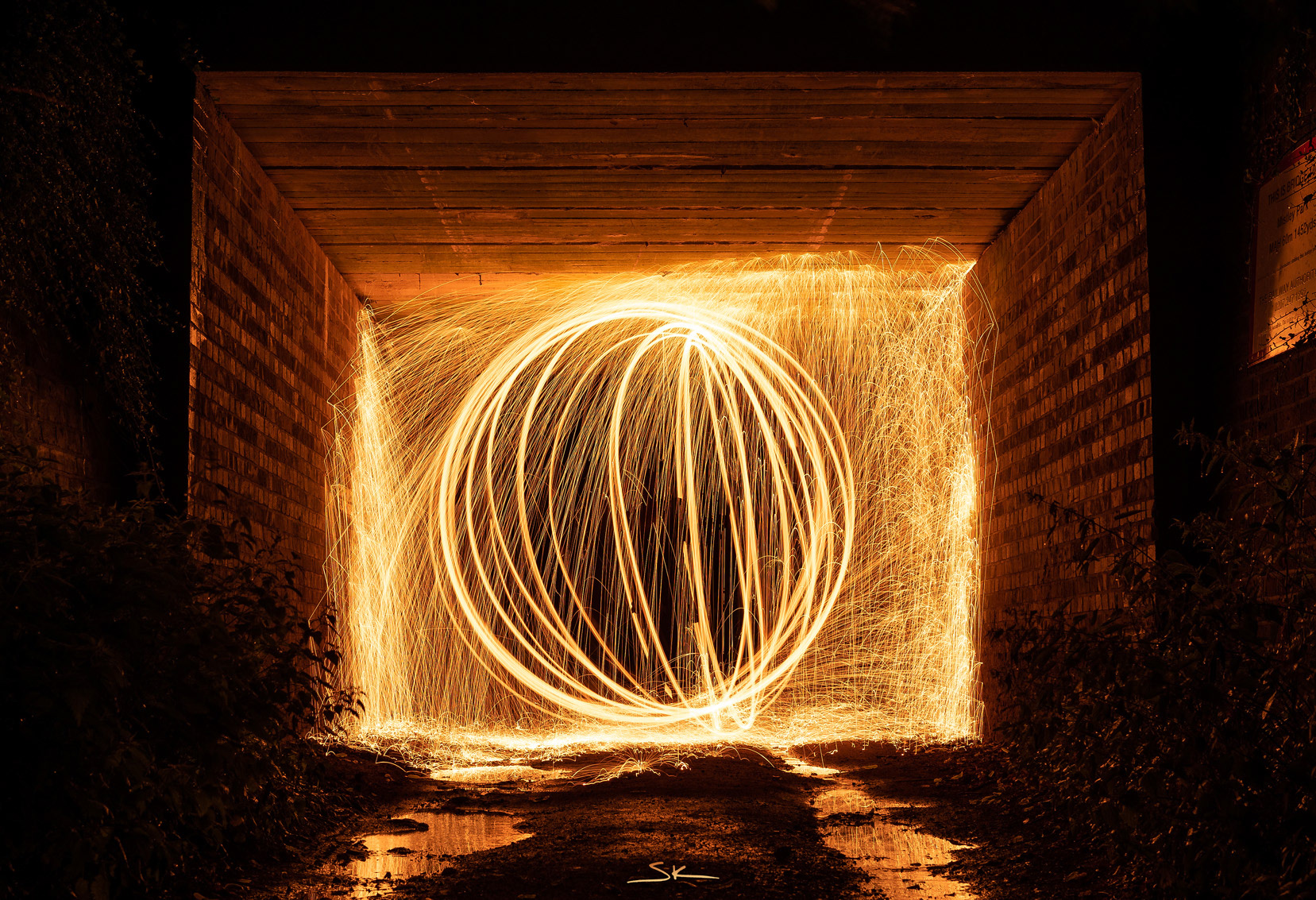 steel wool spinning in tunnel under a bridge