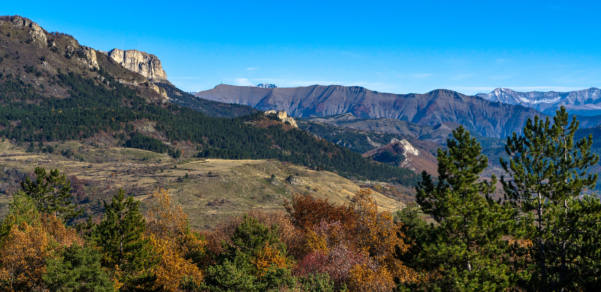 Le massif du Blayeul (2189m) mais pas que, de gauche vers la droite : la grande Aiguille de la montagne de Mélan, l'extrémité Sud de la barre de Géruen, le sommet de l'Estrop, le massif du Cheval Blanc. Au plan intermédiaire : les roches du Villard et des Brigands