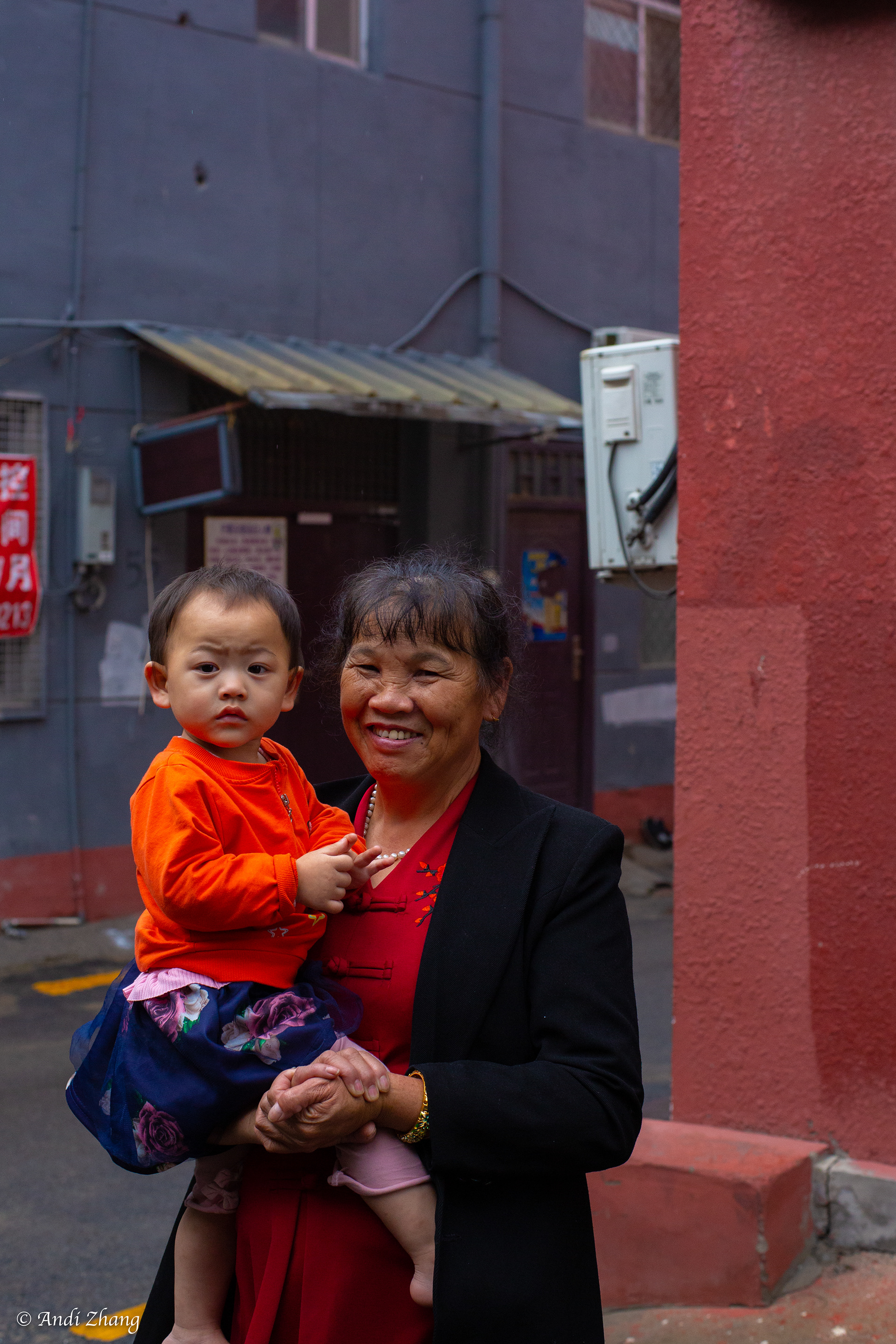A lady holding her grandson is standing around the corner. September 14, 2020.