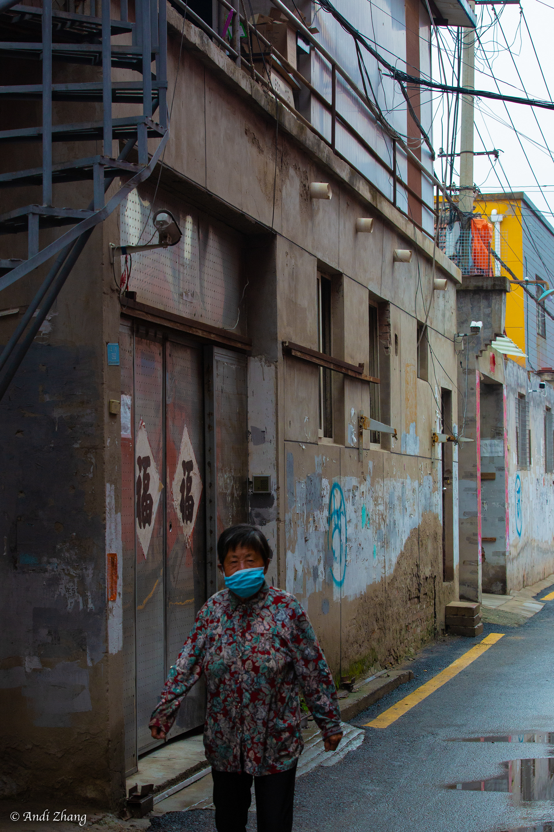 A woman is walking pass a dilapidated building. September 14, 2020.