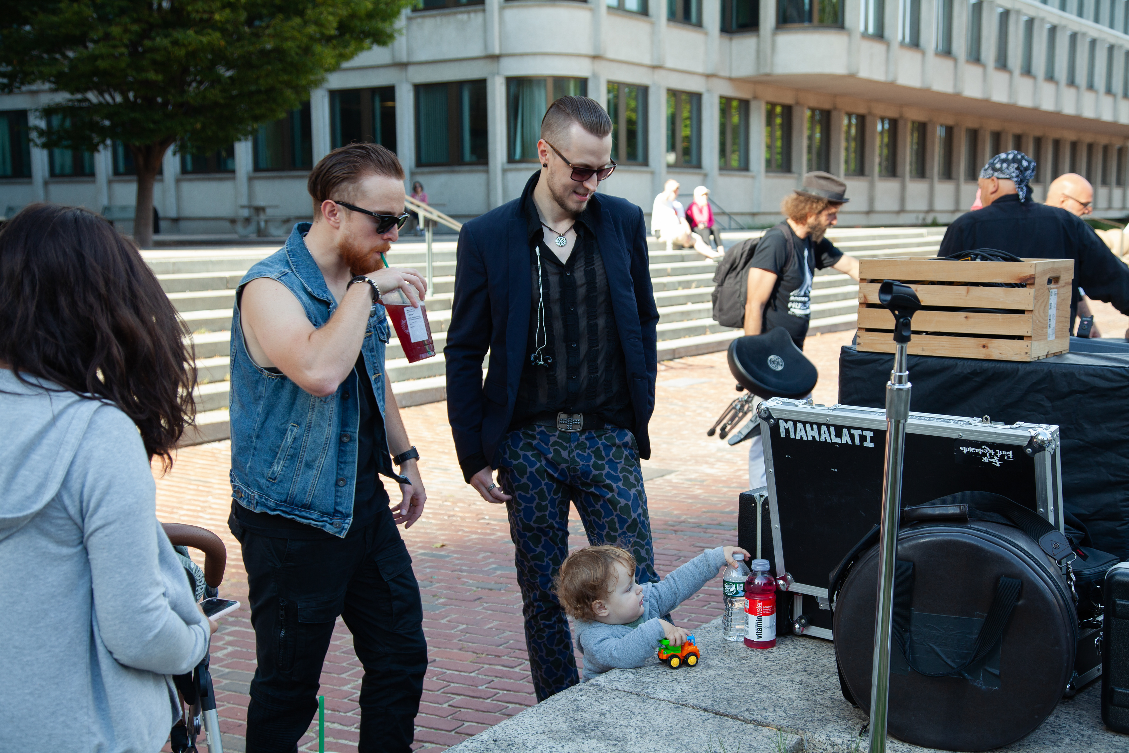 The lead vocal Alex Nekrylau and percussionist Chris Cucinotto were waiting for their show to begin, while a mother took her baby wandering at the square. So the two musicians gently watched as the baby had strong curious about the bands’ instruments.