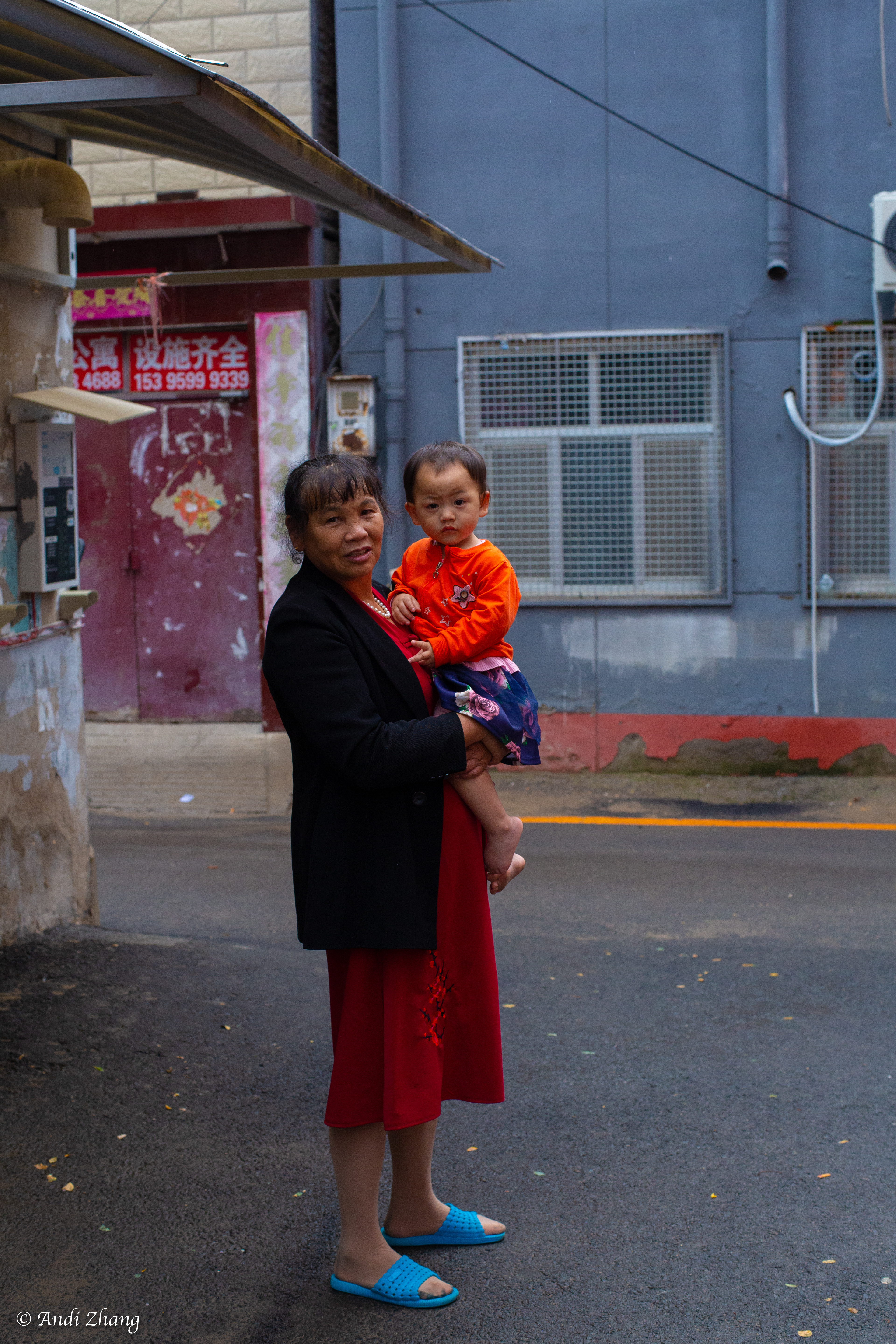 A lady holding her grandson is standing around the corner. September 14, 2020.