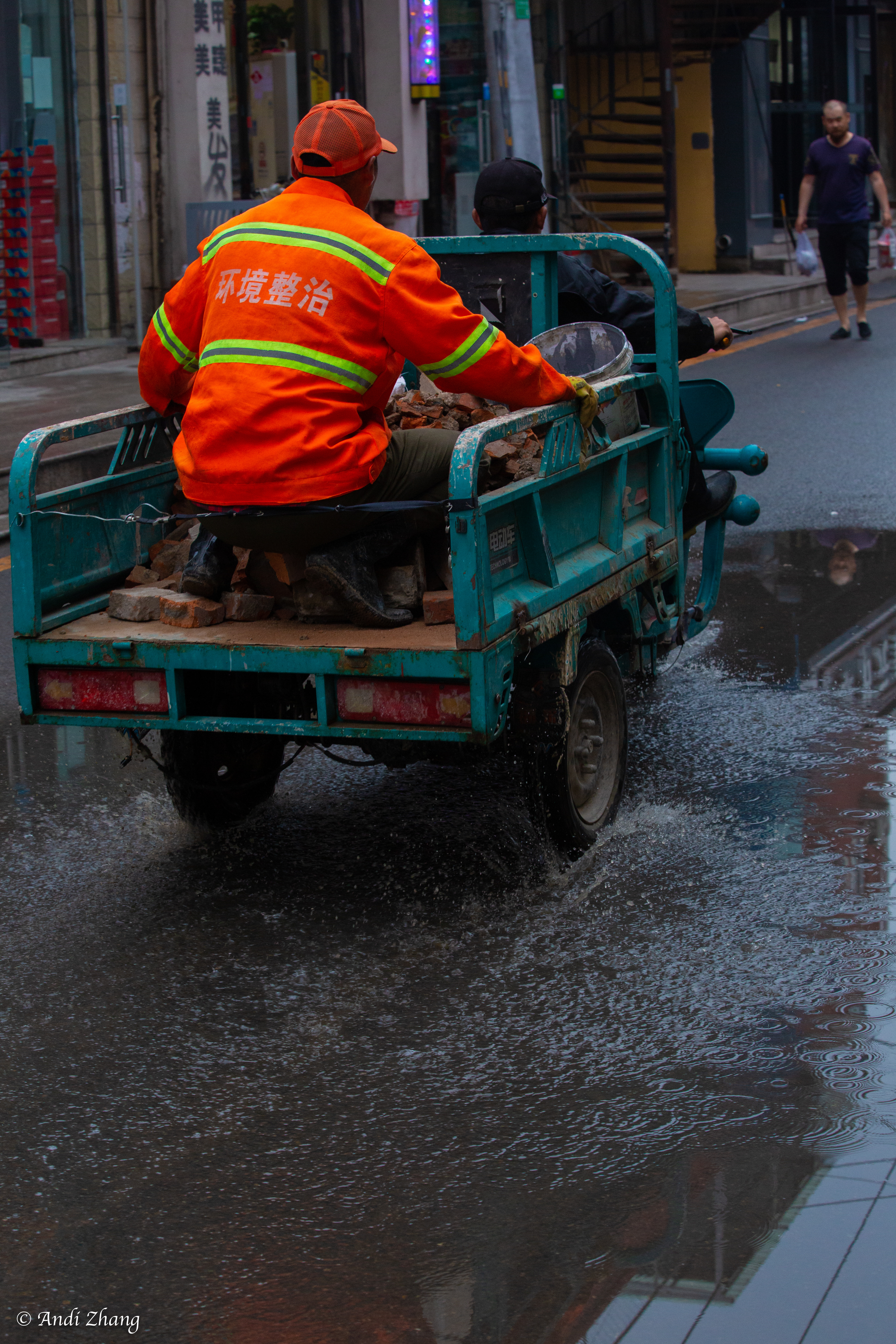 An electric tricycle passing the puddle. September 14, 2020.