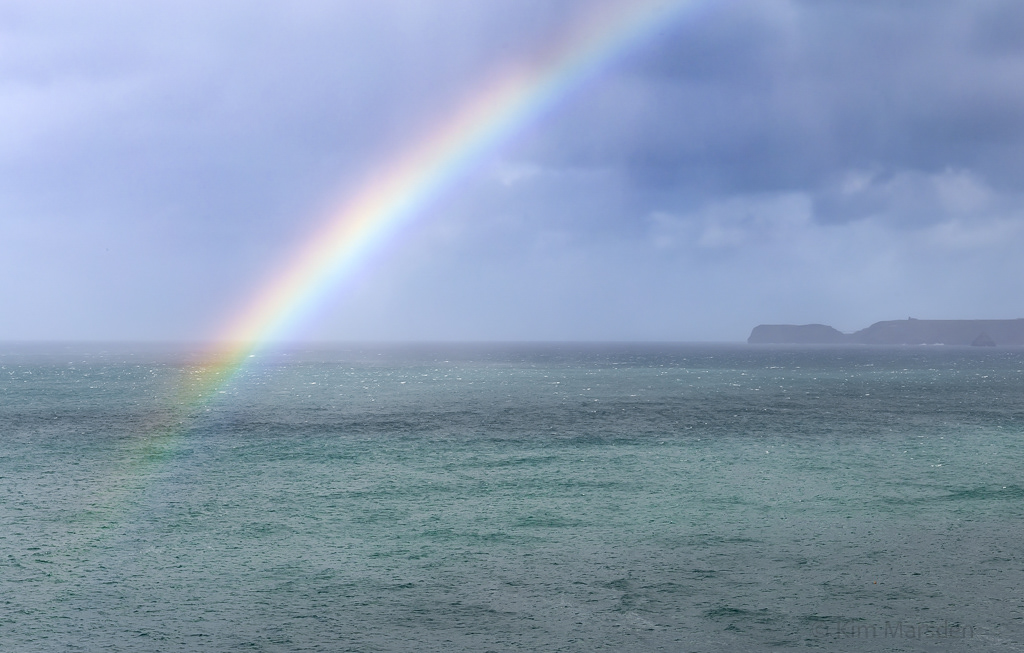 Rainbow with passing storm looking towards Tintagel Castle
