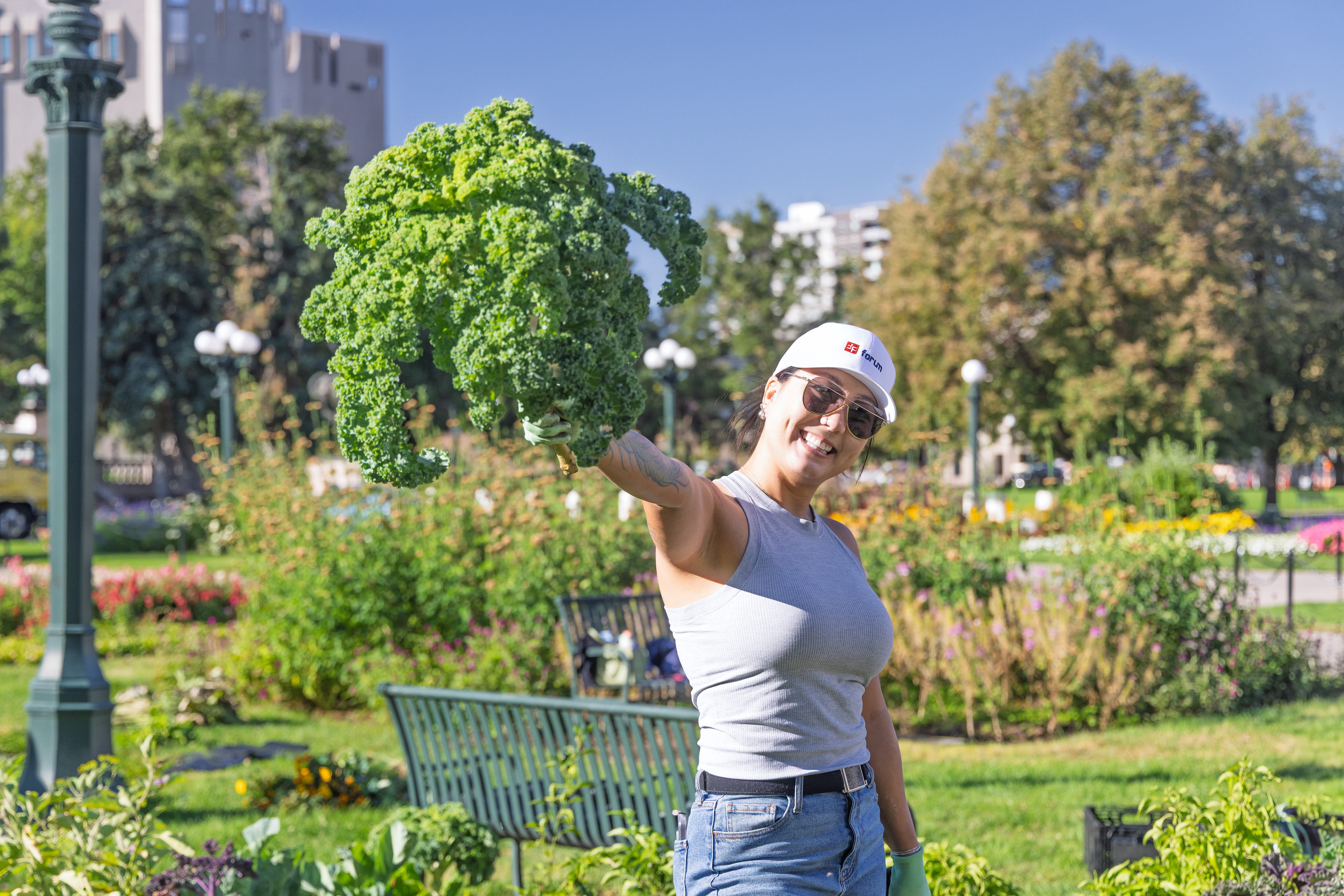 A volunteer at a community gardening event to feed the homeless shares here enthusiasm for kale.  Denver, Colorado