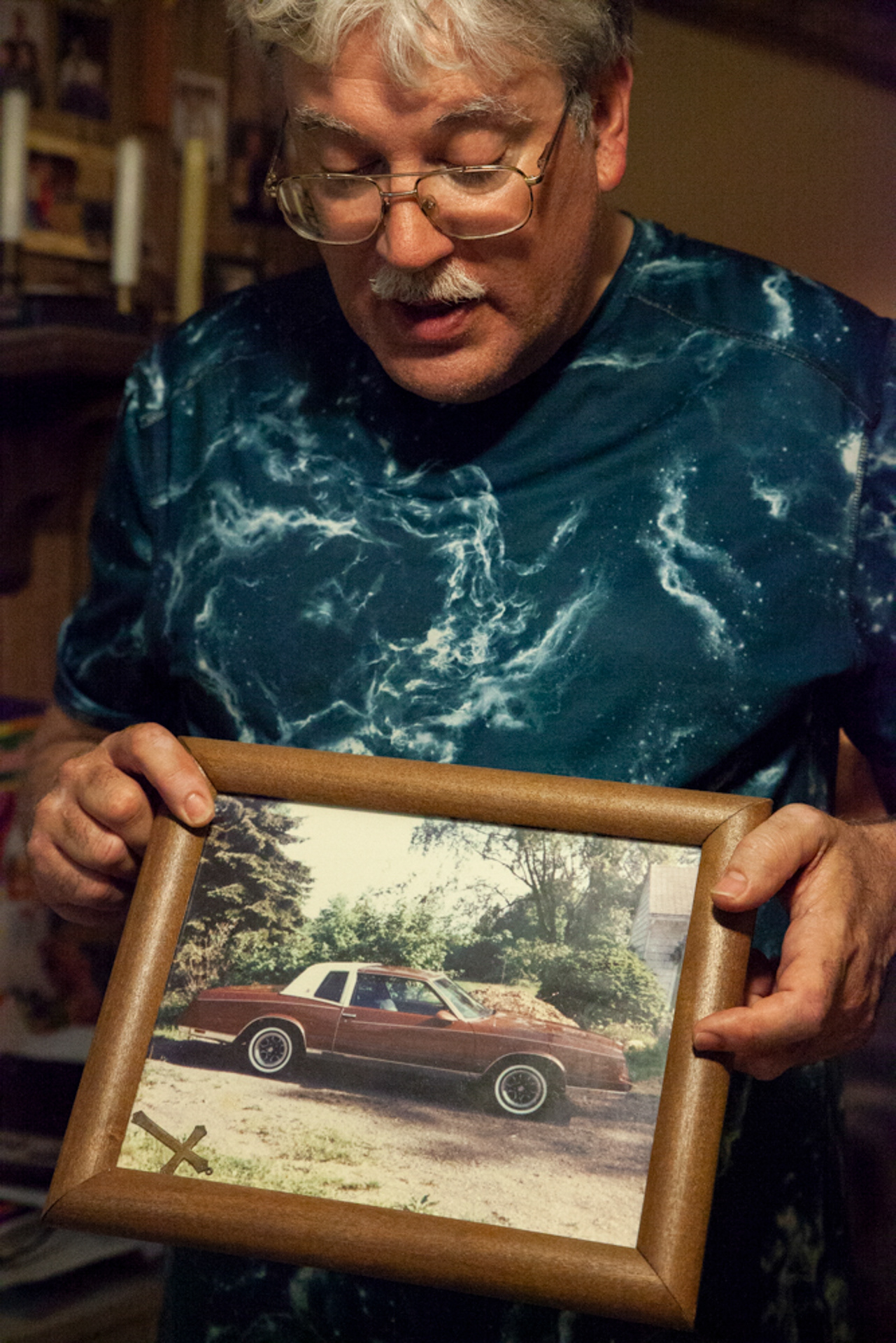 Christopher Ewing, 57, of Albany, Ohio, holds up a picture of his favorite 1986 Monte Carlo he named "Star" inside of his mobile home in Albany, Ohio. "It was real great until it started talking to me," remarks Ewing, a man who lives with schizophrenia, adding that he found out at the age of 24 that he had schizophrenia when the car didn't stop talking.