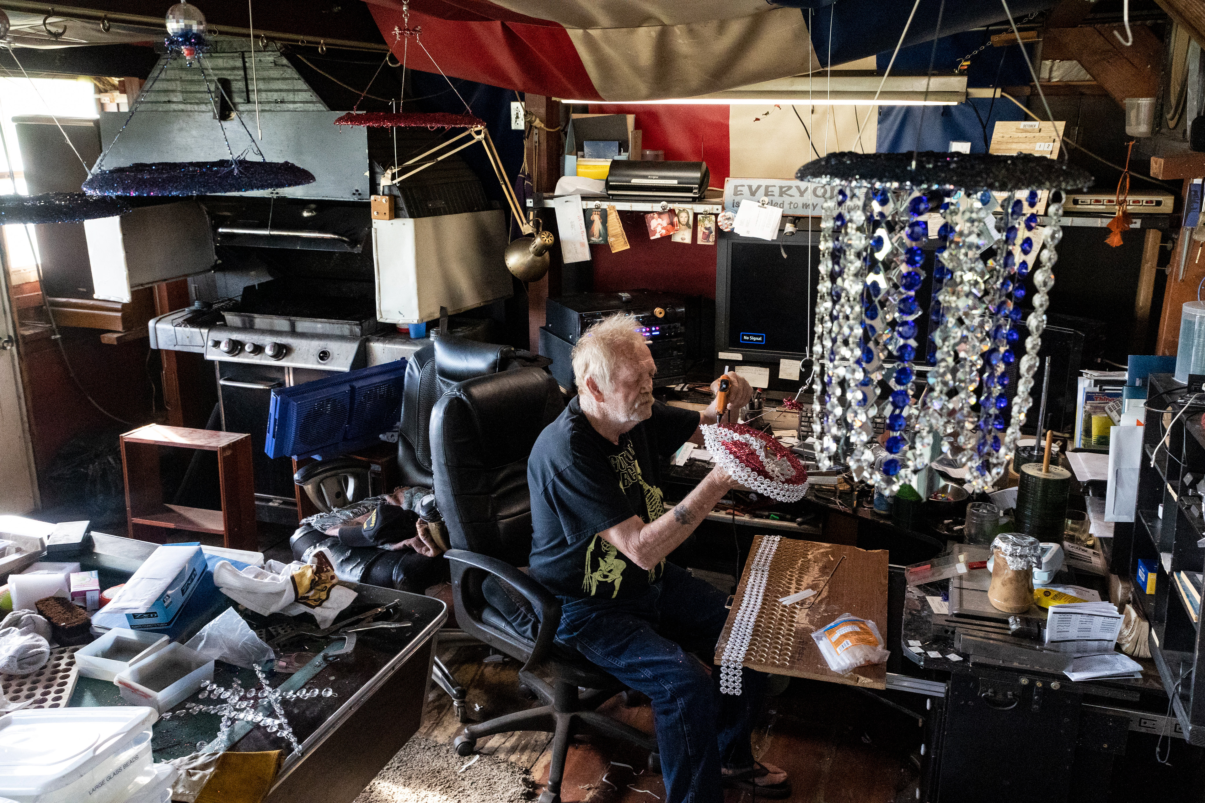 Bill Moore, 87, of Stony Ridge glues beads to a plate he has covered in glitter to make lawn ornaments he hangs in his yard and gives to friends in his home in Stony Ridge on Wednesday October 13, 2021. Moore said, “It’s to keep my mind going. I can’t just sit and watch tv all day I’d go crazy.”