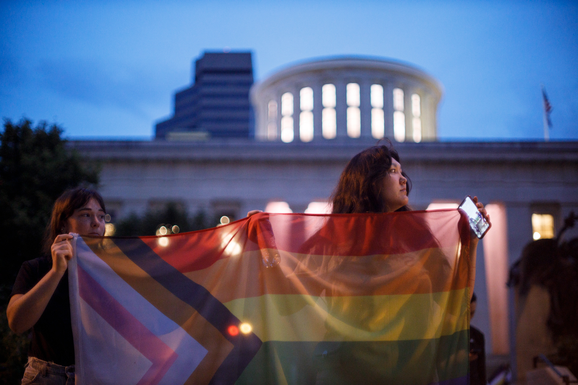 Activists hold an Inclusive Pride flag in front of the Ohio Statehouse in Columbus, Ohio on June 24, 2021. Protesters organized quickly to combat a last minute amendment to an Ohio bill that would ban trans women from participating in female sports.