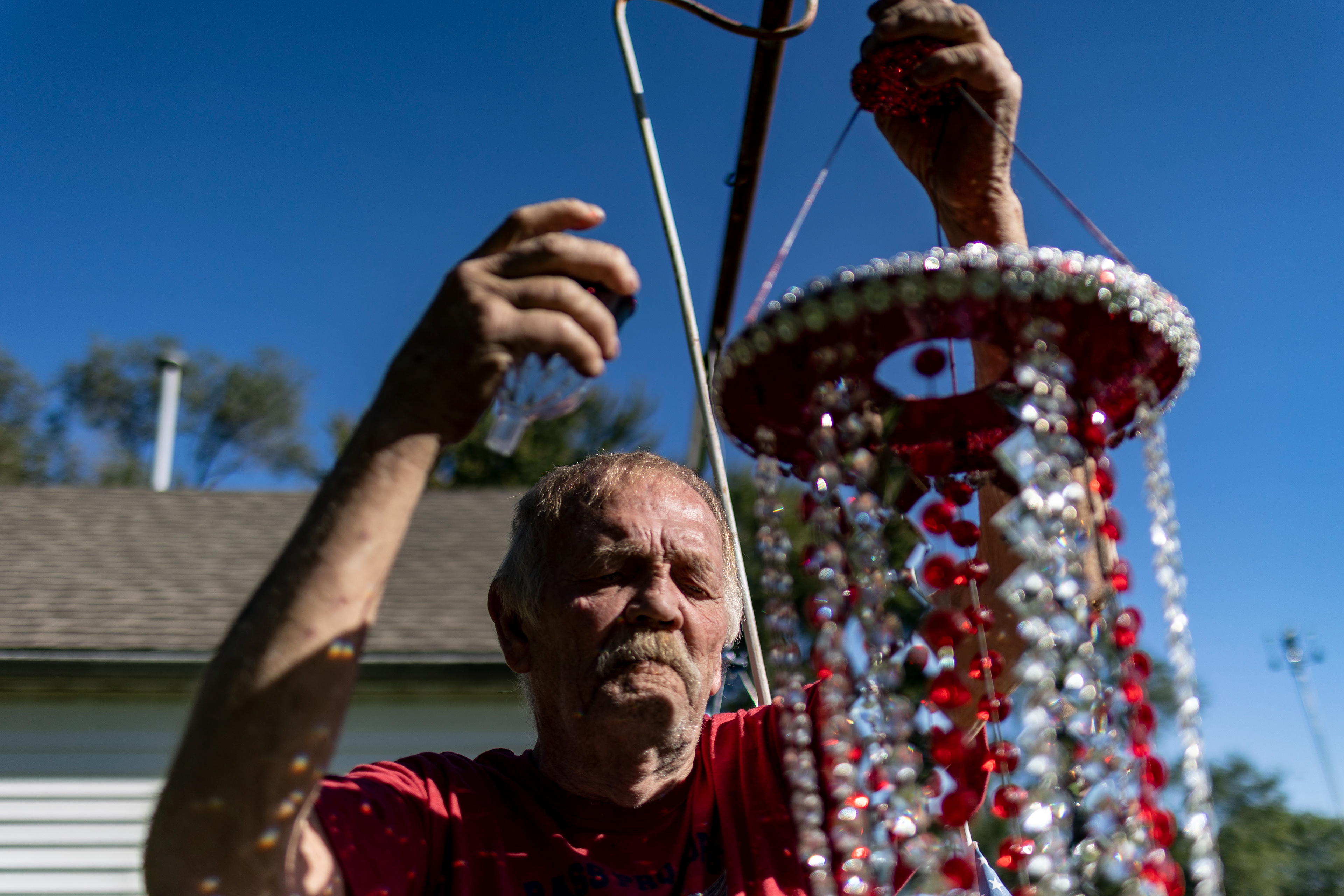  Bill Moore changes one of his decorative mobiles in his backyard in Stony Ridge, Ohio on Wednesday September 29, 2021. Moore mentioned he started making the decorations after his wife died adding, “Yeah...yeah it gives you something to do. I give em away. I don’t know, it’s kinda crazy.”