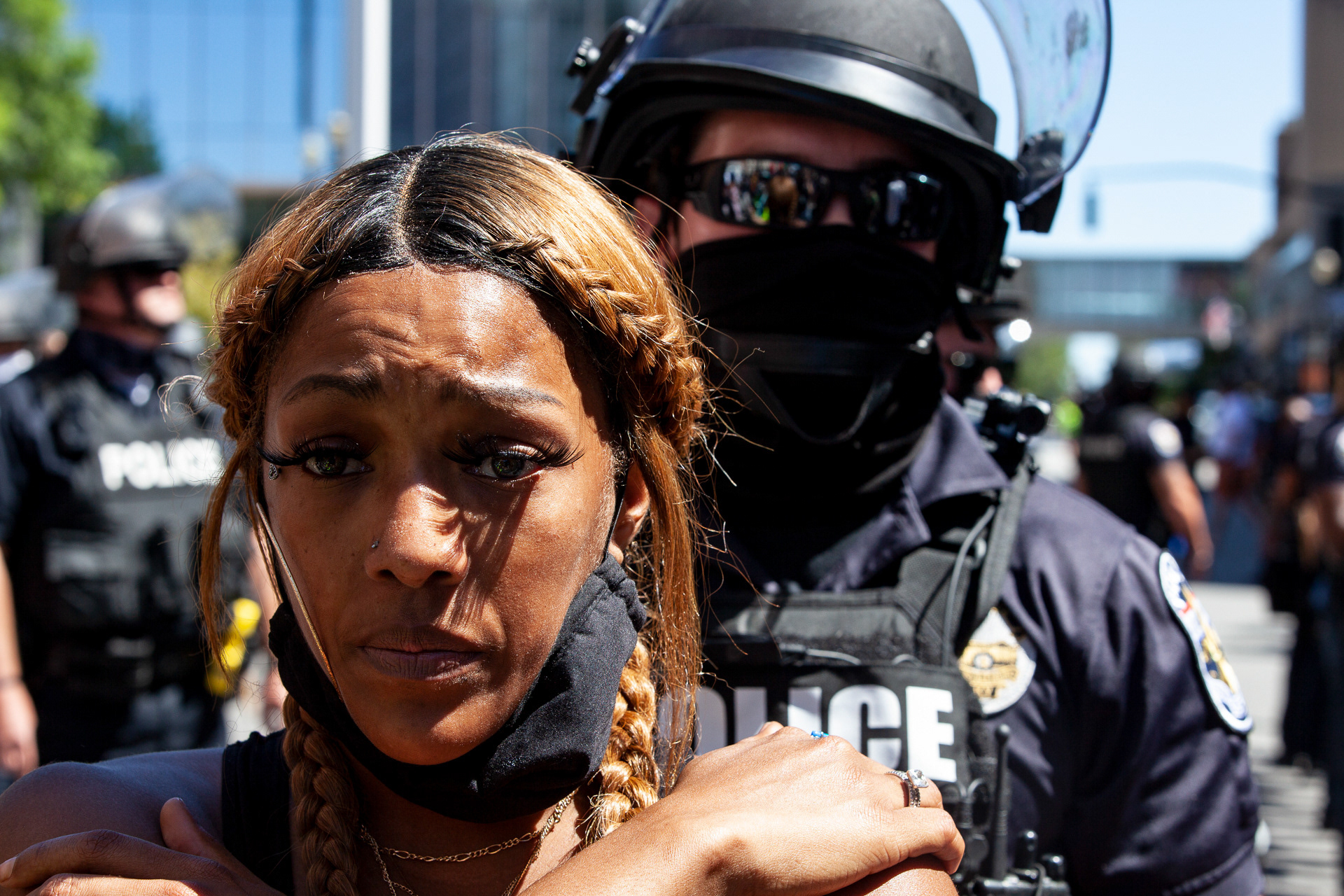 Protester in support of Black Lives Matter stands with her back to the Lousiville Metro Police Department police line in Louisville, Kentucky on September 5, 2020.
