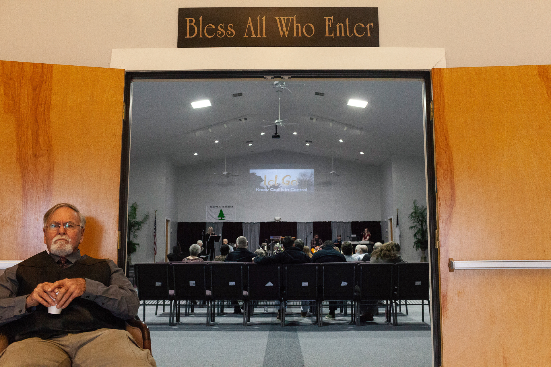 Bill Smith, of Vinton County, sits in the foyer of Calvary Assembly of God in McArthur, Ohio, watching the entrance to the church on a Sunday morning, Mar 3, 2019.