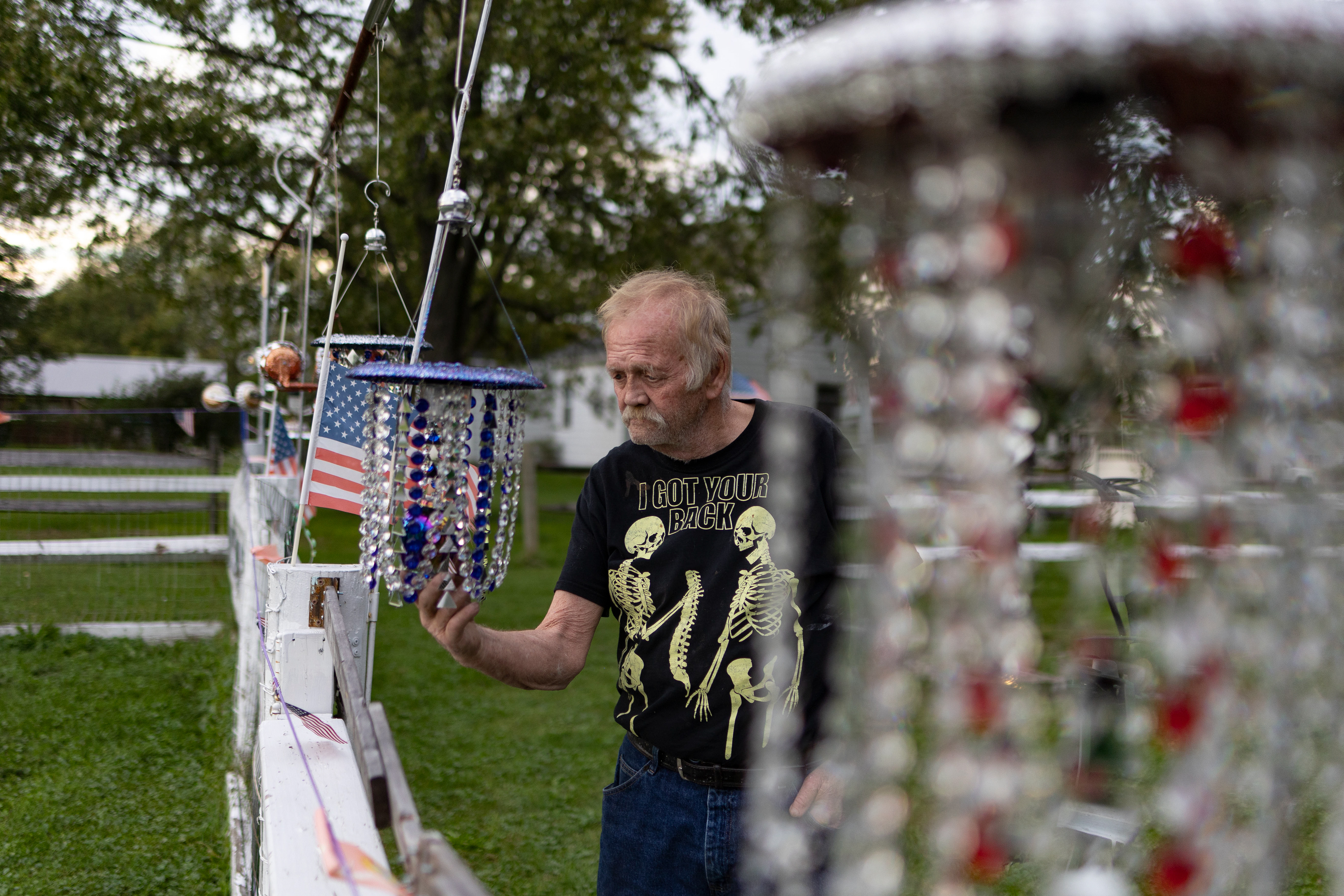 Bill Moore adjusts one of his decorations that is hanging around the perimeter of his home in Stony Ridge on Wednesday October 13, 2021.