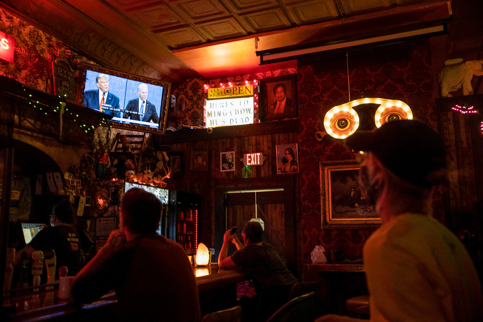Patrons eagerly watch the second presidential debate at Oddfellows Liquor Bar in Columbus, Ohio while observing COVID-19 restrictions on Oct. 22, 2020. The second presidential debate lasted from 9pm to 10:30pm, and the statewide COVID-19 restriction on liquor sales after 10pm had many bars in Columbus, including Oddfellows, closing before the debate was over. 