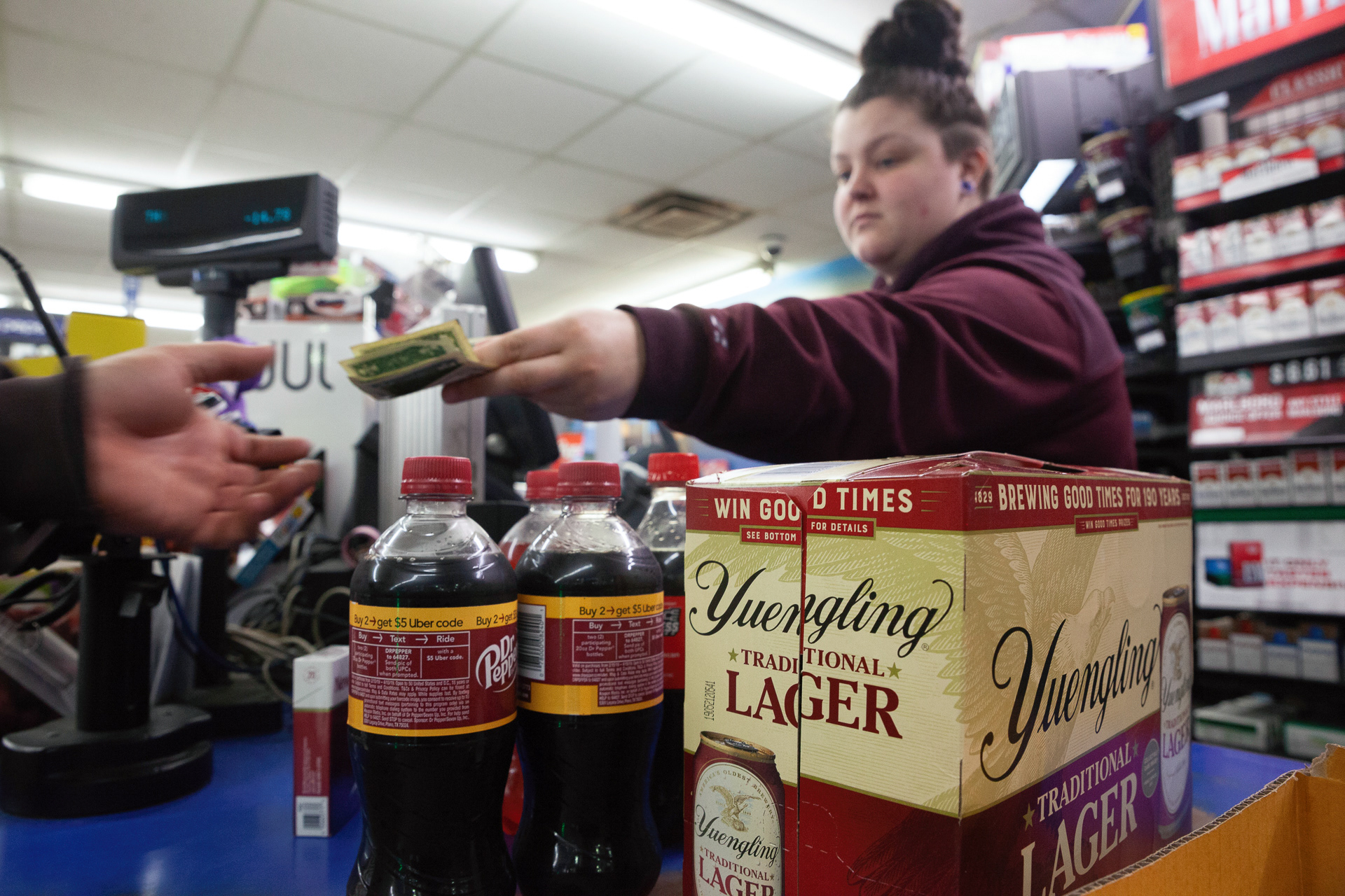 Rylee Cunningham, 21,  of Athens, Ohio, sells alcohol and Dr. Pepper to Fred Gamble, 38, of Albany, Ohio, at the Marathon Station in Alexander, Ohio, Mar 21, 2019. Albany, Ohio has been a dry village for over a century, and the closest vender of alcohol is the Marathon Station down the street.