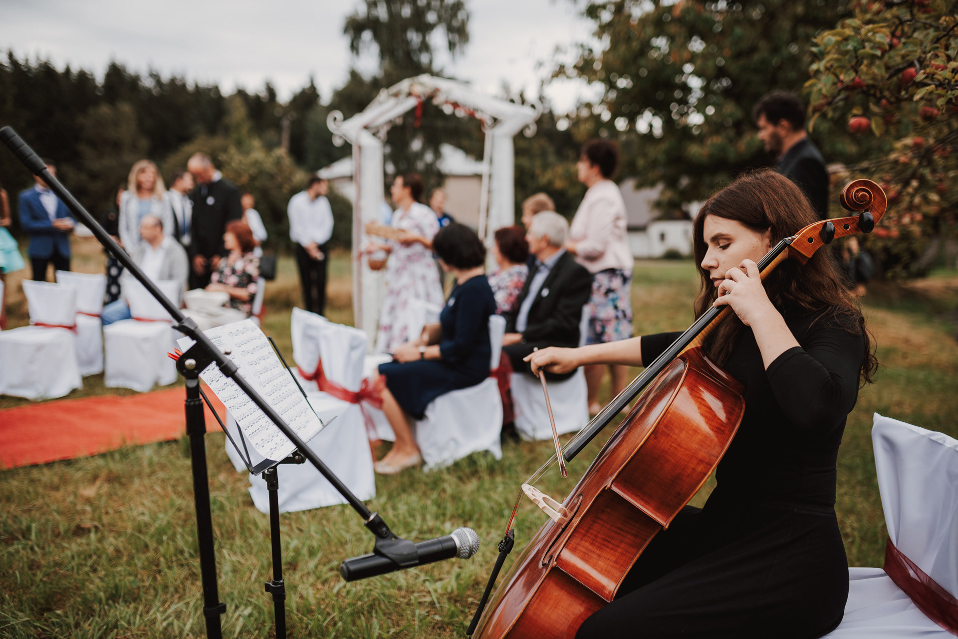 mladá žena hraje na violoncello u obřadu