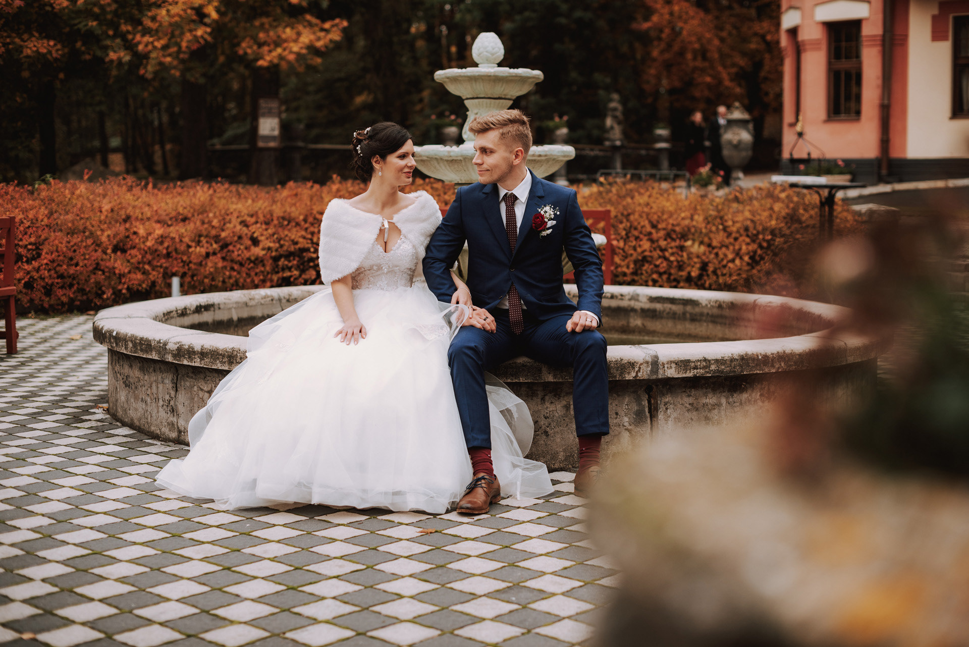 novomanželé sedí na okraji fontány před Letohrádkem svatý Vojtěch